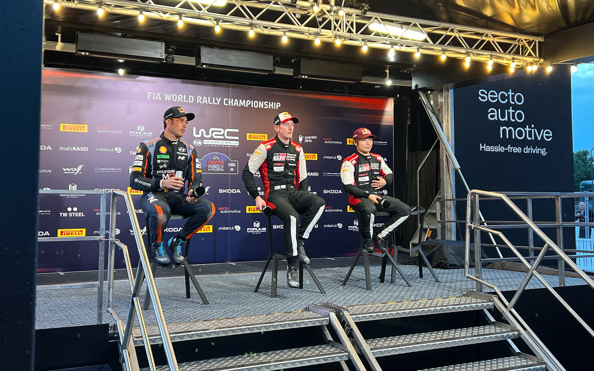 デイ2終了後のインタビューステージ。中央が総合トップのエルフィン・エバンス選手、左が2位のティエリー・ヌービル選手、右が3位の勝田貴元選手