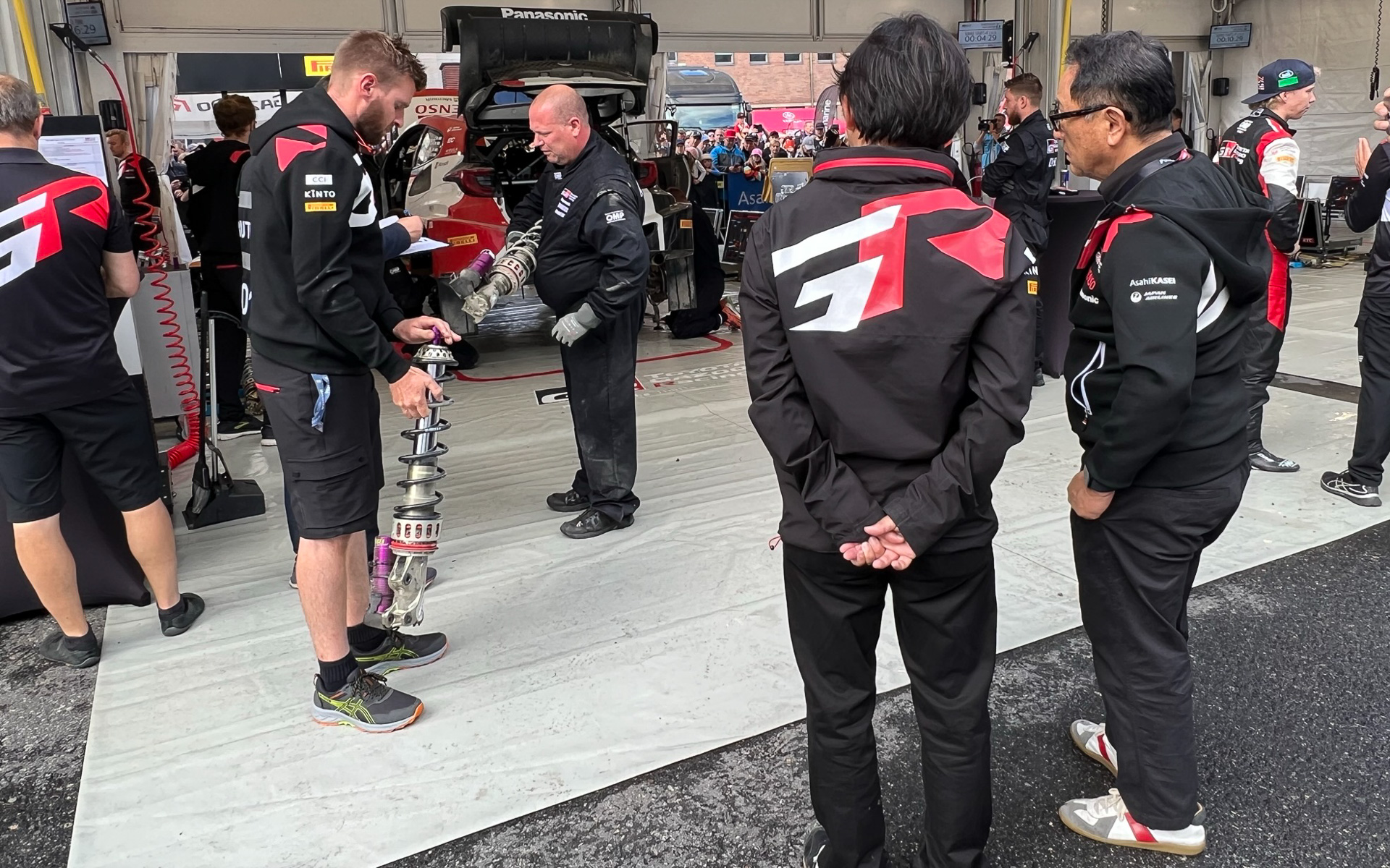 チーム作業を見守る豊田章男会長（右）。隣に立つTGR-WRT 社長兼CEO 春名雄一郎氏にあれこれ質問