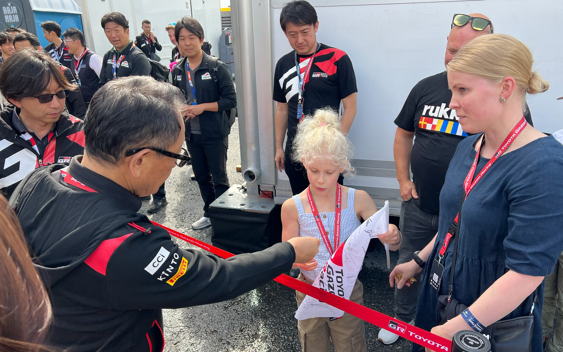 チーム代表代行として積極的にファンサービス。スーパー耐久やスーパーフォーミュラでも積極的にピットウォーク参加をしている豊田章男氏だが、その姿勢はフィンランドでも変わらない。サイン後、新バージョンのモリゾウステッカーをプレゼント