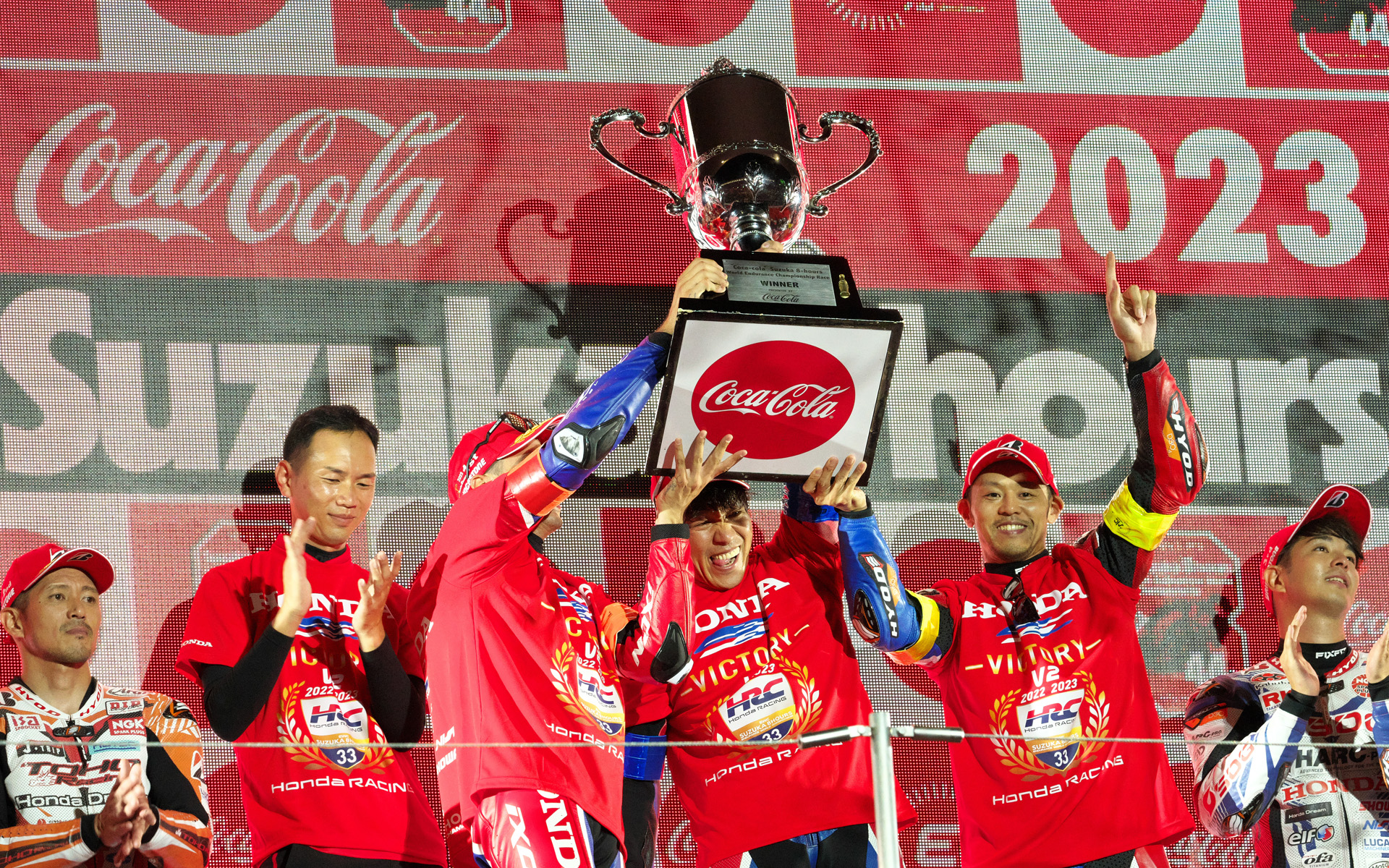 表彰台でトロフィーを掲げる33号車のライダーたち