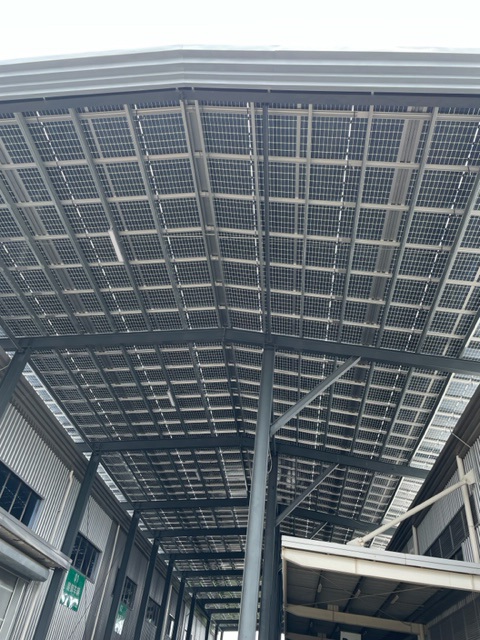 工場と倉庫間の連絡通路。連絡屋根は路面からの反射光からも発電できるパネルを採用