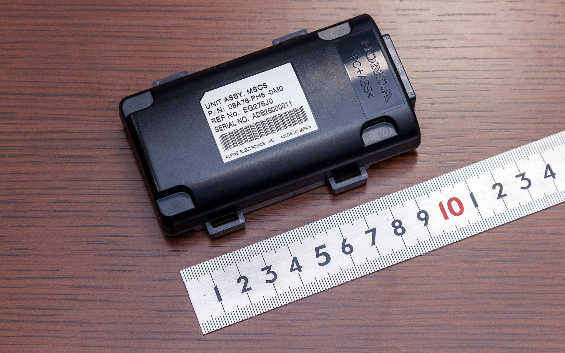 「リアカメラ de あんしんプラス」の本体ユニットは、ダッシュボード裏のすき間への設置を前提に開発しているのでとてもコンパクト。設置するための金具まで作成してしまうとコストアップにつながるため、結束バンドで固定しやすい形状にして、低コストを実現している