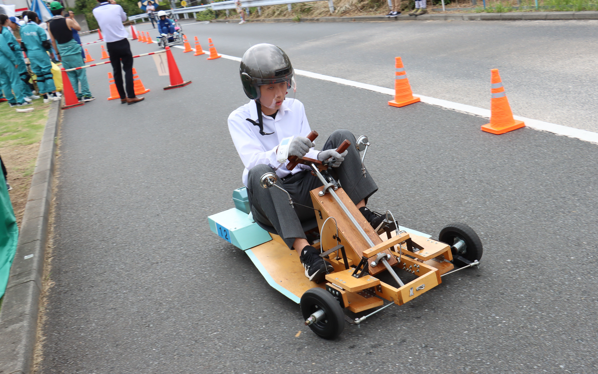 次のドライバーがICカードの入った腕章を受け取り、コースインしていく