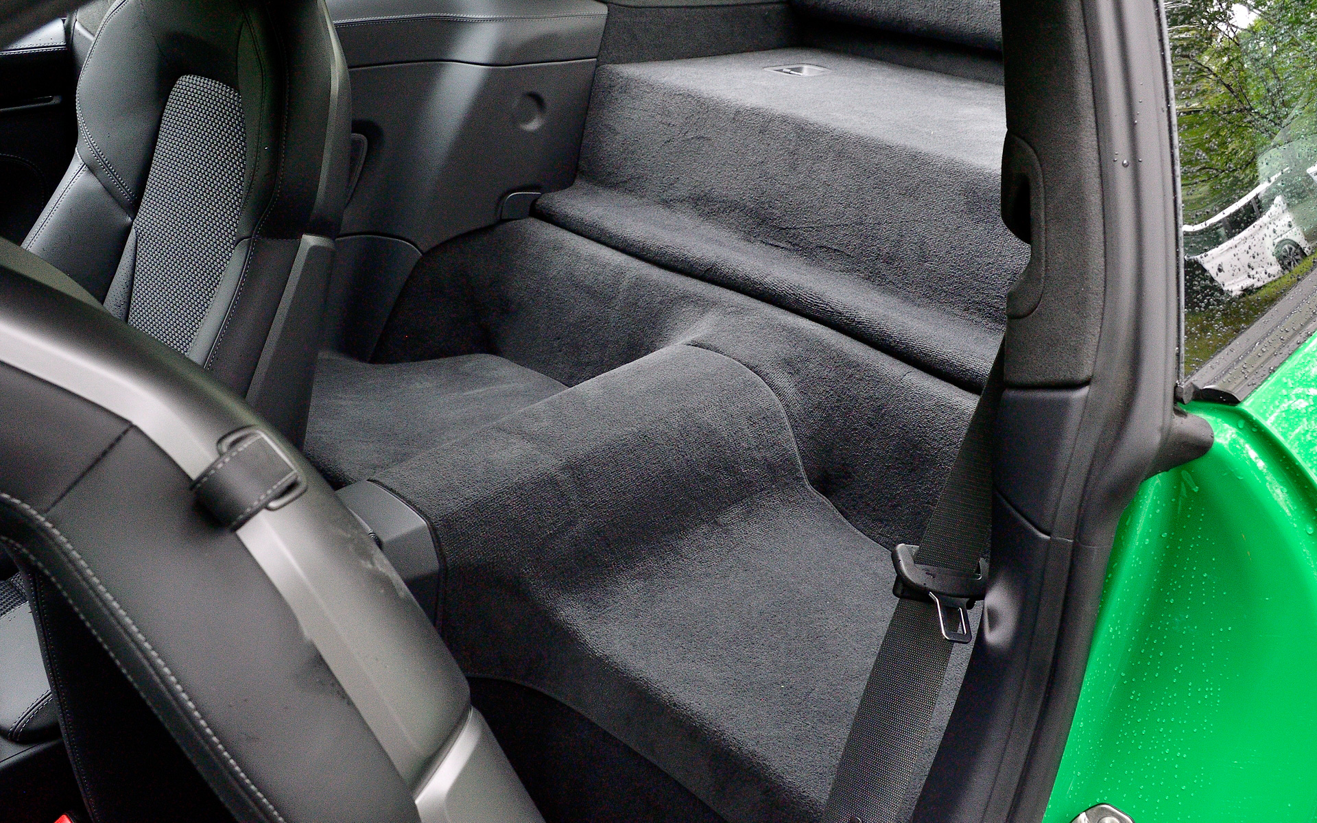 マットブラックとハイグロスブラックの2トーン仕上げられたインテリアでは、4Wayスポーツシートプラスを標準装備。また、オプションの「カレラTインテリアパッケージ」（撮影車は装着）を選択すれば、シートベルトの色をスレートグレーまたはリザードグリーンから選べるほか、ヘッドレストにエンボス加工される911ロゴやシートセンターのストライプも同じカラーで仕上げられる