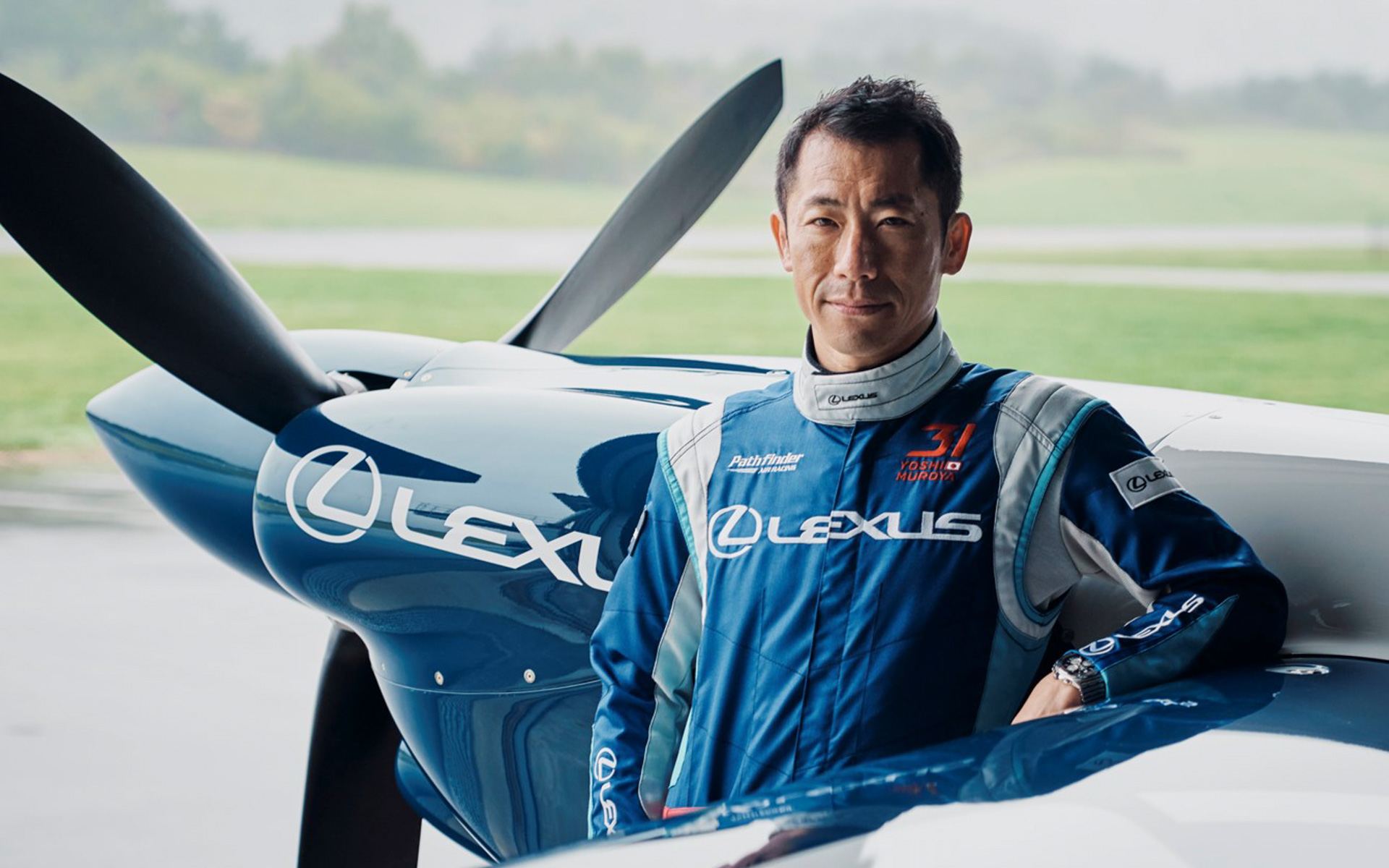 室屋義秀選手プロフィール。幼少期よりパイロットを志し、中央大学入学後、航空部でグライダーを開始。2009年、国際航空連盟（FAI）公認の3次元モータースポーツシリーズ「レッドブル・エアレース・ワールドチャンピオンシップ」に初のアジア人パイロットとして参戦。2016年千葉大会で初優勝。2017年ワールドシリーズでは全8戦中4大会を制し、アジア人初の年間総合優勝を果たす。2023年10月には、新たなエアレース「AIR RACE X（エアレース エックス）」の主催・参戦予定