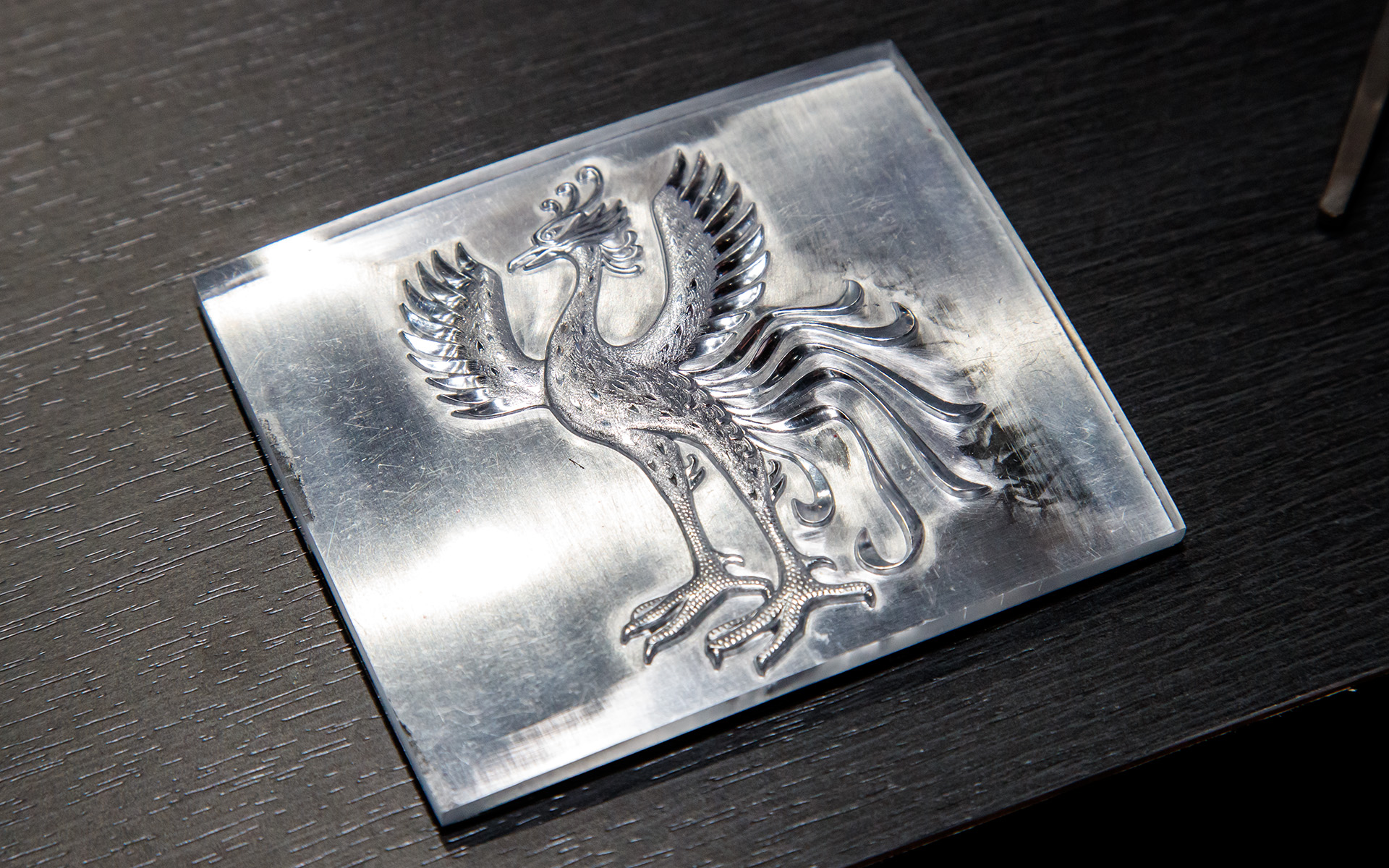 こちらはフロントエンブレムの金型（オス）。鋳造で大まかなカタチを作った後に職人が羽の模様などを打ち込んで仕上げられた