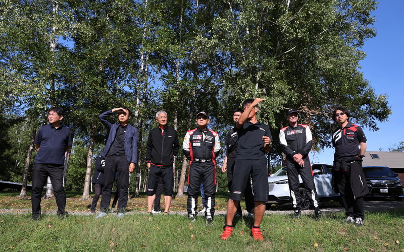 ラリー北海道でコースの下見を行なうトヨタ自動車 代表取締役 豊田章男会長（中央）。後方にはユハ・カンクネン選手の姿やホンダ車を見ることができる