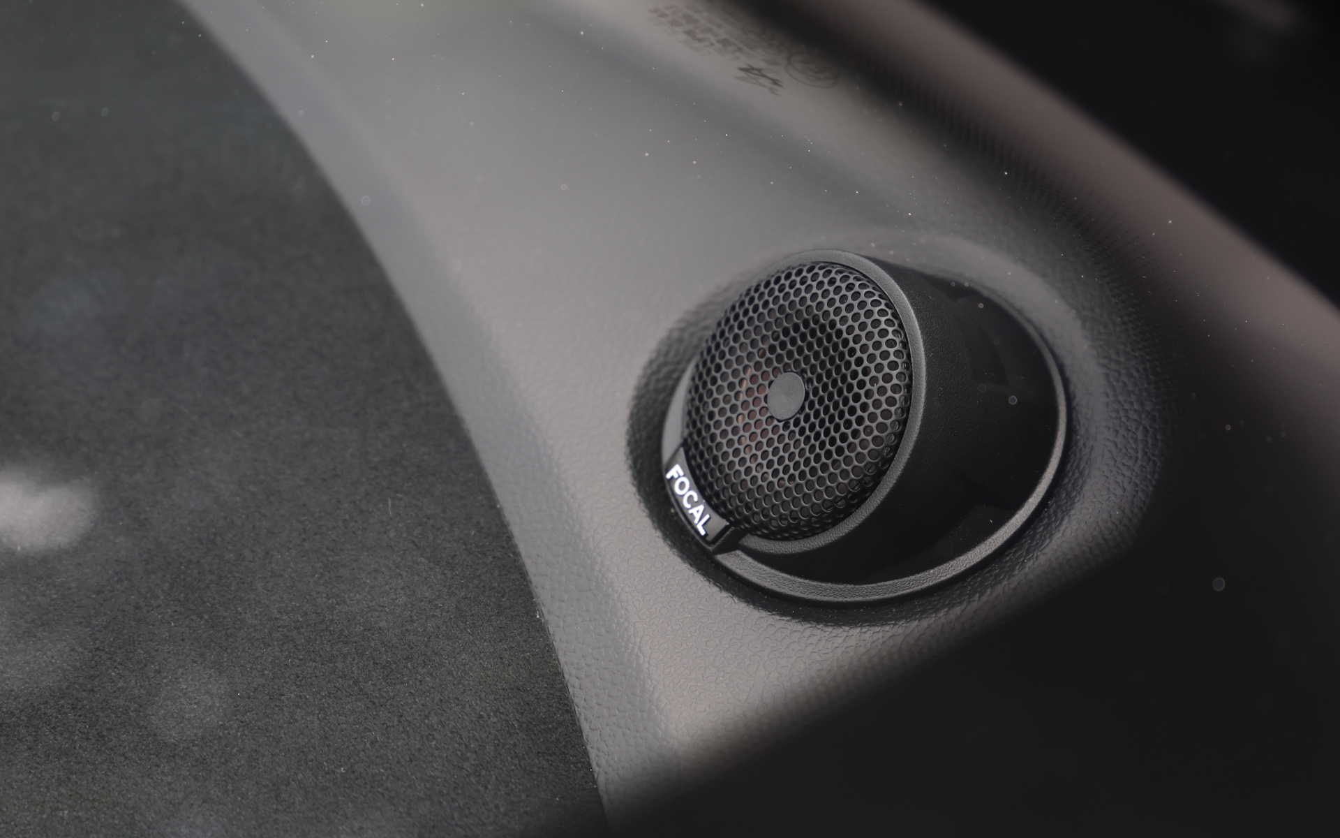 一見するとSabelt製軽量フルカーボンモノコックバケットシートとSabelt製6点式レーシングハーネス、真っ赤なドアストラップによってスパルタンな印象だが、ステアリングやルーフトリム、ダッシュボード、センターコンソール、ドアパネルなどに用いられたマイクロファイバーで中和。オーディオはFOCAL製軽量4スピーカーを搭載する