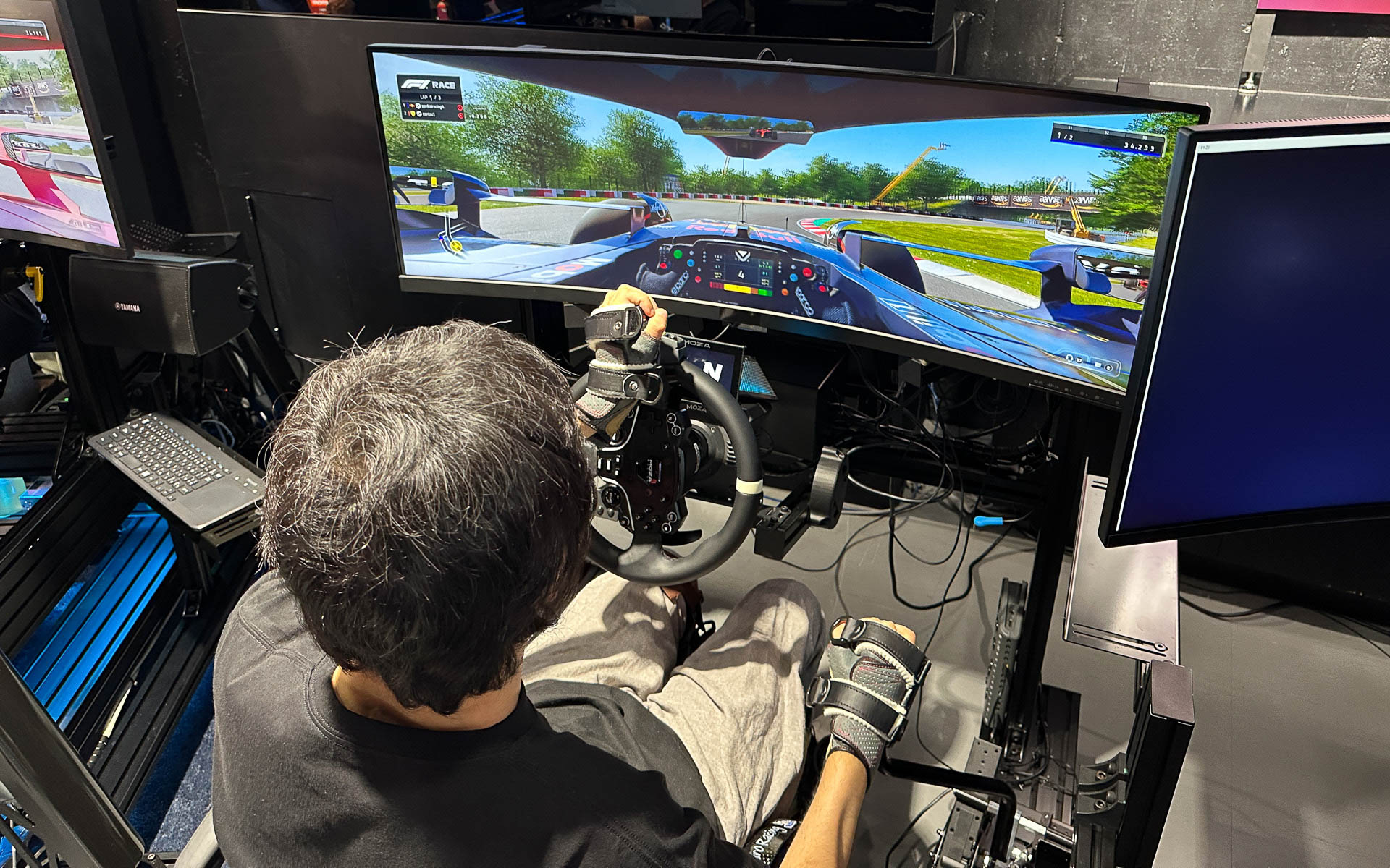 手動運転装置付きシミュレータで「EA SPORTS F1 23」をプレイする車いすユーザーの長屋宏和さん
