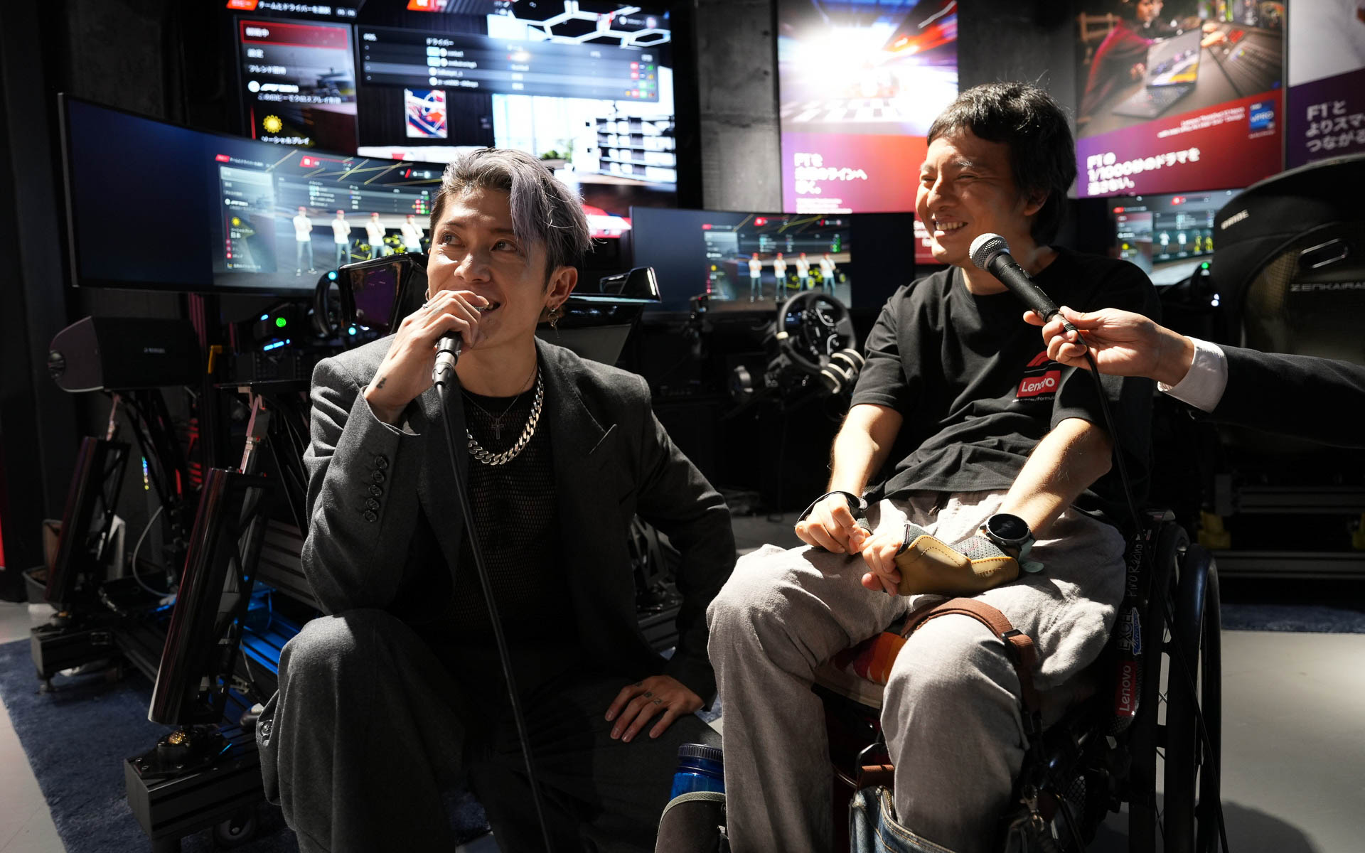 レーシングシミュレータでのバトルを終えてインタビューに答えるMIYAVIさんと長屋さん