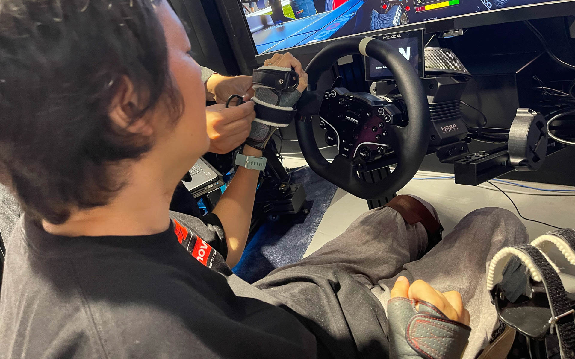 指でステアリングや操作レバーをうまくつかめない長屋さんは、アダプターを使用し、腕をそれぞれに固定して操作