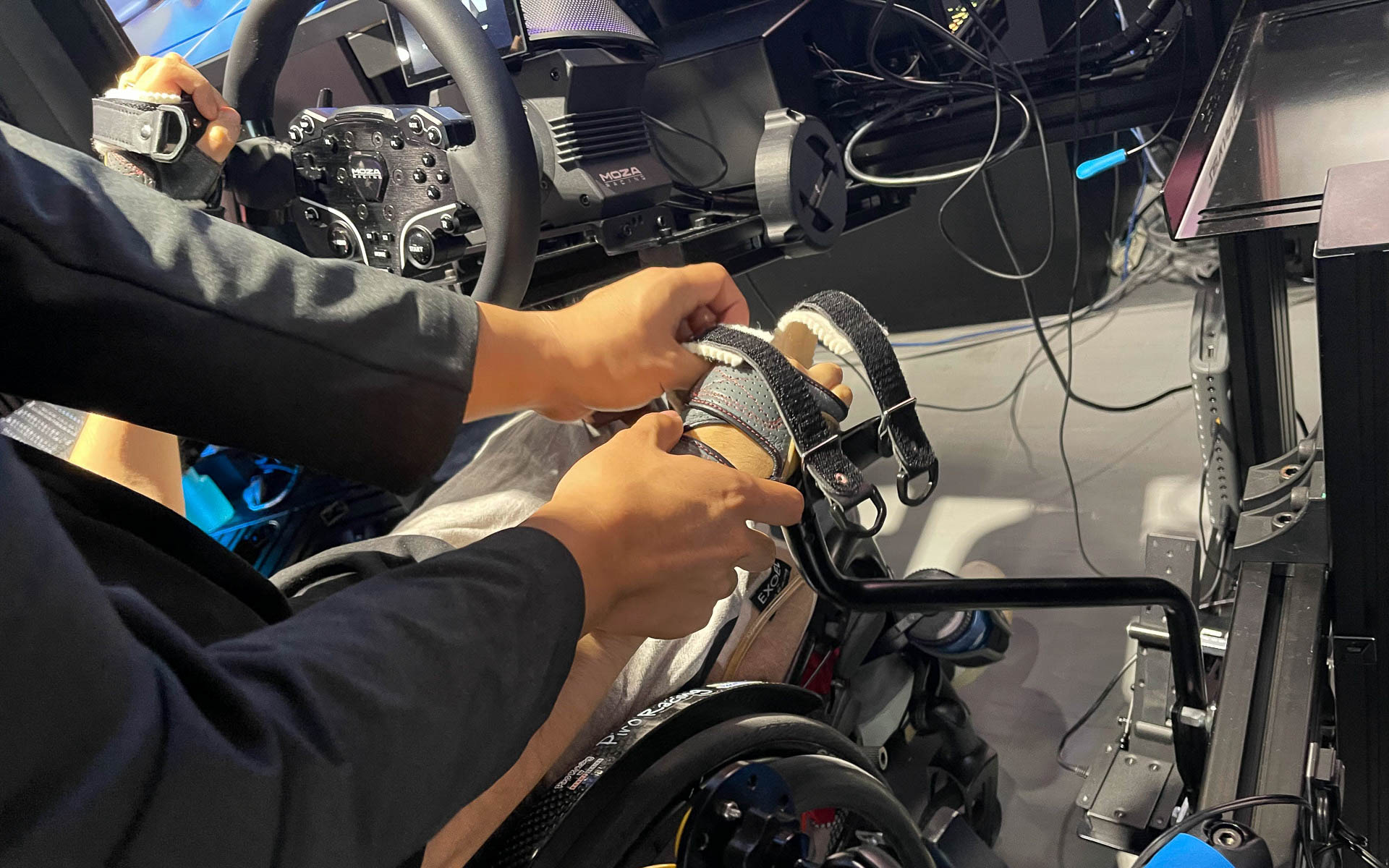 指でステアリングや操作レバーをうまくつかめない長屋さんは、アダプターを使用し、腕をそれぞれに固定して操作