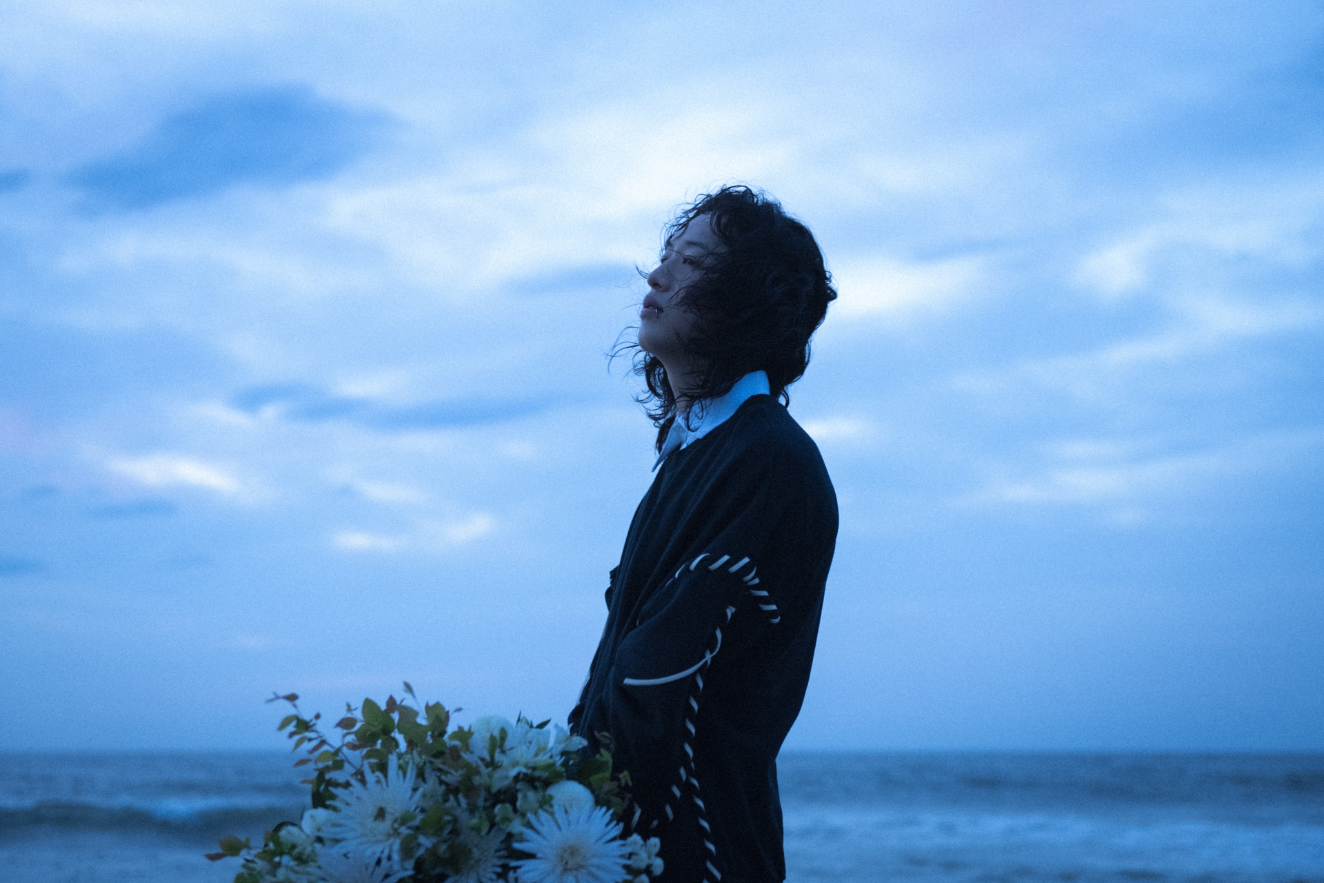 キタニタツヤさんのコメント「Hyundaiは個人的に世界ラリー選手権で注目している企業で、コナが世界的にヒットしているクルマであることも知っていたので、それが日本に上陸する際の橋渡し役として選んでいただけたのは光栄でした。夢を聞かれて答えることがなかった子供時代、何かを夢見ている友人の姿に憧れていました。憧れなんてないよ〜と言いながら、恋に恋するように、憧れに憧れている。それ位“憧れ”はわれわれの存在とくっついていると思います。『憧れのままに』生きること、簡単ではないですが、その願望を歌にしたいと考え楽曲制作に臨んだのですが『カッコいいギターカッティングと、古くて新しいシンセイントロが作れないとこの曲はダメだ!』と早い段階で考えていて、その両者がツル〜と出てきてくれた時に『行けるぞ』と自信を持てました。イントロのギターを思いついたときの映像を備忘用で撮っておいたのですが、今見てみたらその時の自分の身なりがボサボサすぎて、当時の自分の苦労っぷりに同情してしまいました」