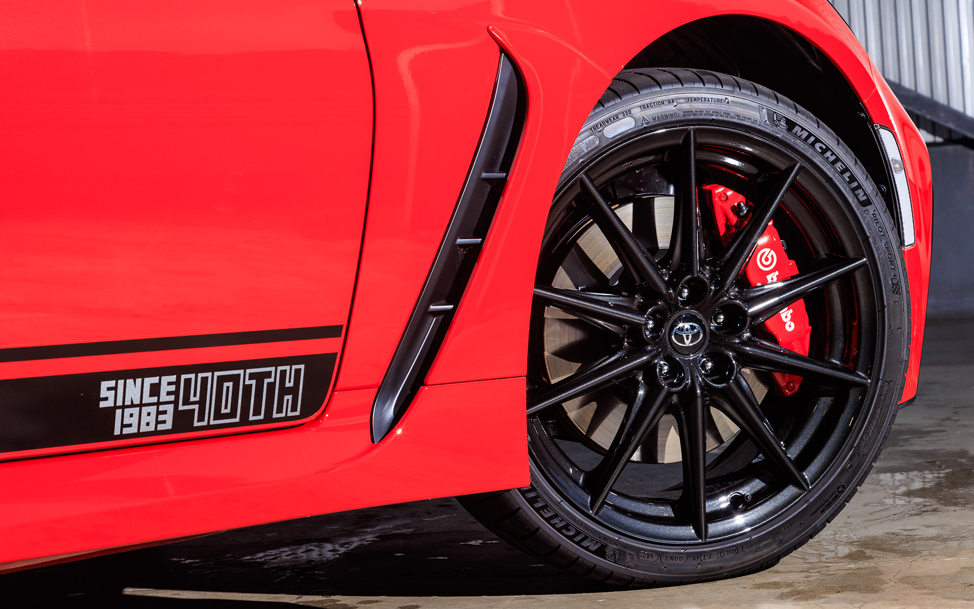 ミシュラン「パイロット スポーツ 4」の215/45R18タイヤにダークグレーメタリック塗装のアルミホイールが組み合わされる。ドアの40周年記念デカールは販売店装着オプション