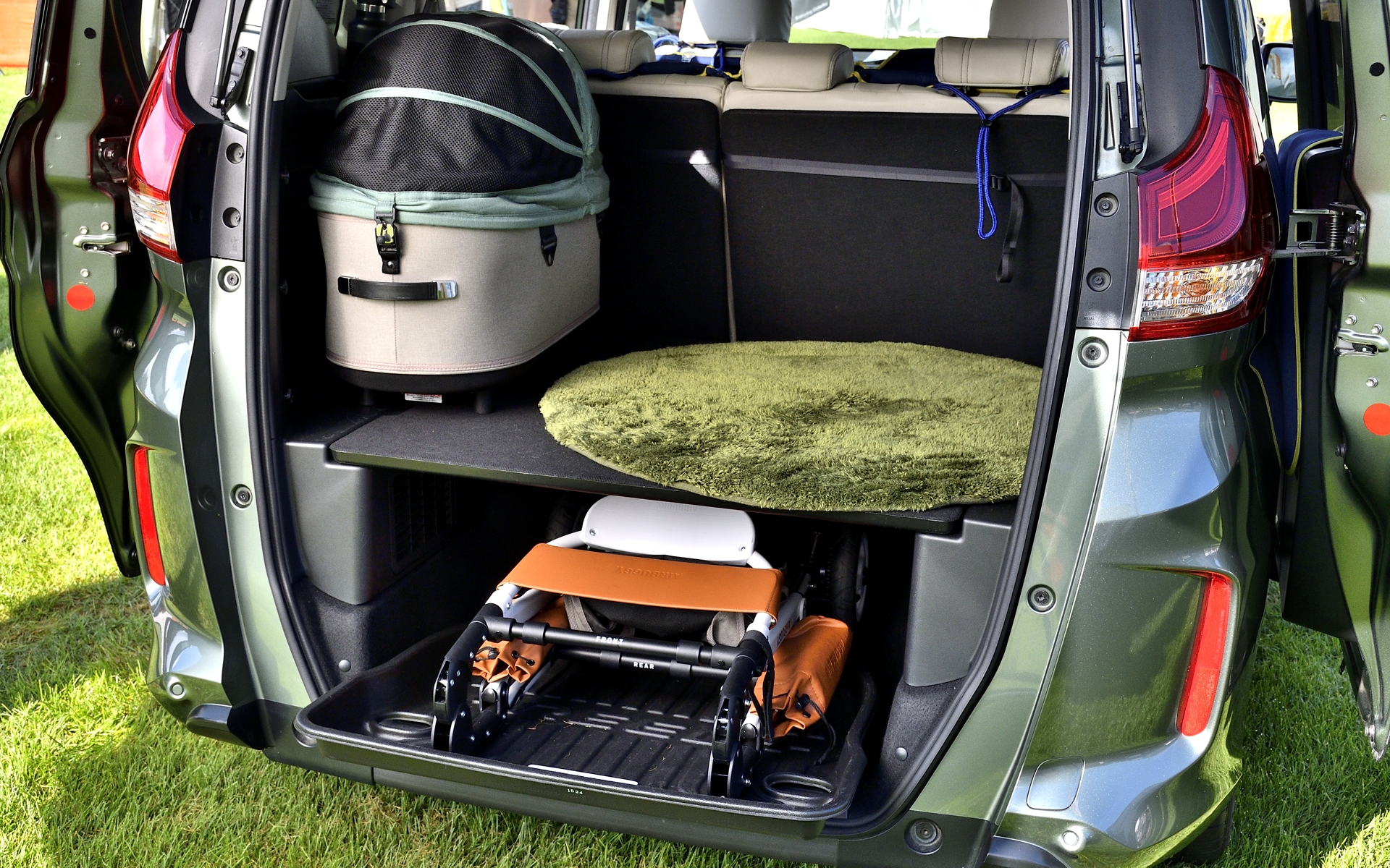 フリード＋は低床という特徴を生かしてラゲッジスペースが2段に分かれている。下段スペースには写真のように畳んだペットバギーがちょうど収納でき、純正アクセサリーの「ラゲッジトレー」を一緒に使うと汚れが防げるだけじゃなく、ペットバギーの取り出しも便利に。それを知った来場者は「これは便利！」と驚いていた