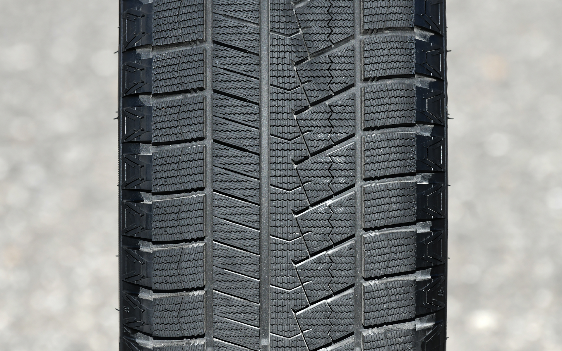 写真左がIN側、右がOUT側。トレッドパターンは非対称パターンとし、イン側に雪上でトラクション性能を発揮する横溝をレイアウトするとともに、アウト側に剛性の高い大きなブロックを用いた。また、「3Dサイプ」の採用によりサイプ同士が噛み合うことでブロックの倒れ込みを防ぎ、ブロック剛性を確保。これにより接地面が安定し、氷雪路での走行安定性とハンドリングを向上させている