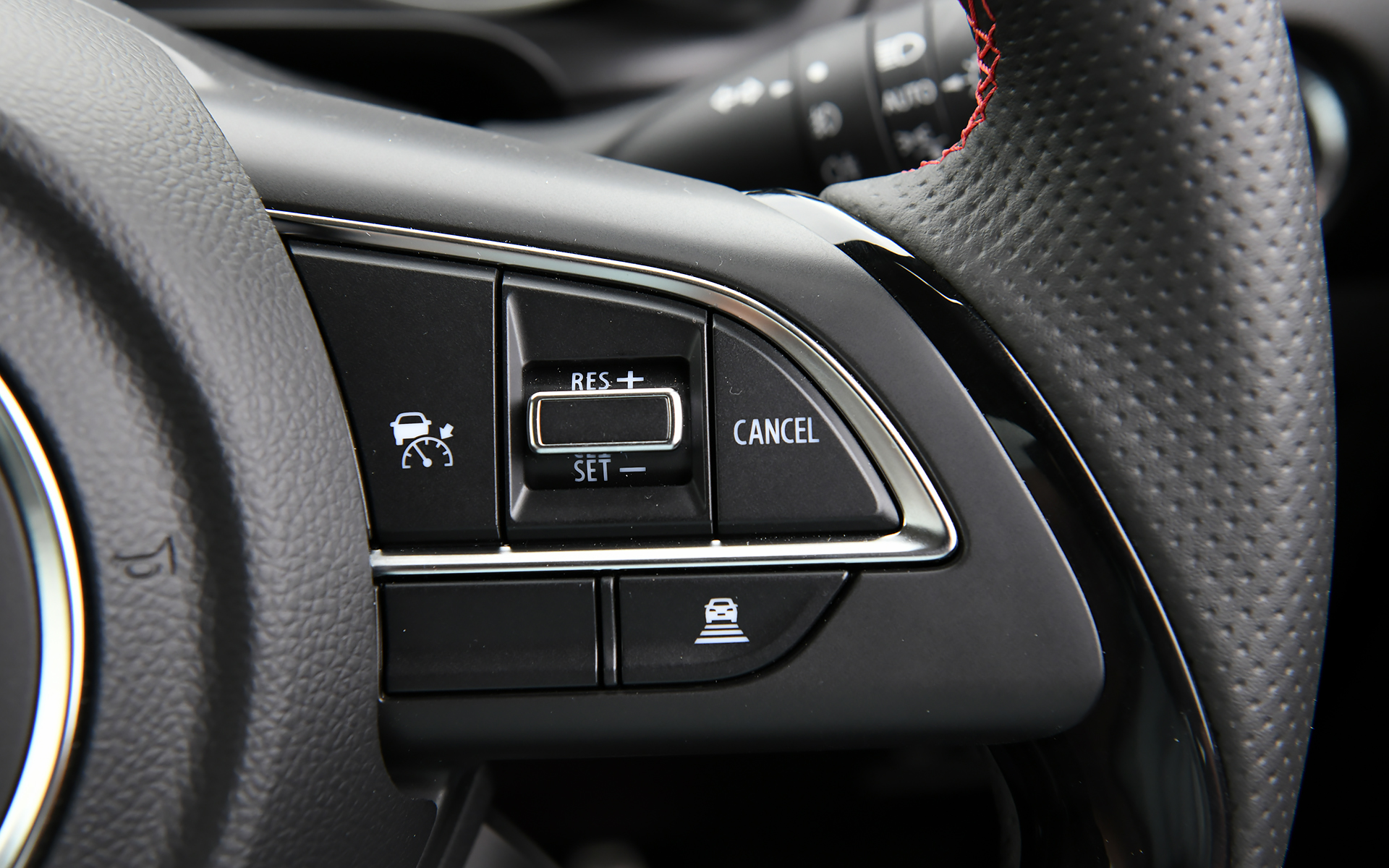 Sport専用のレッドステッチ入り本革巻ステアリングホイールを装備。右側ステアリングスポークにはアダプティブクルーズコントロール（ACC）のスイッチが配置される。また、ステアリングから手を離さないで操作できる位置に車線逸脱抑制機能のスイッチを設定