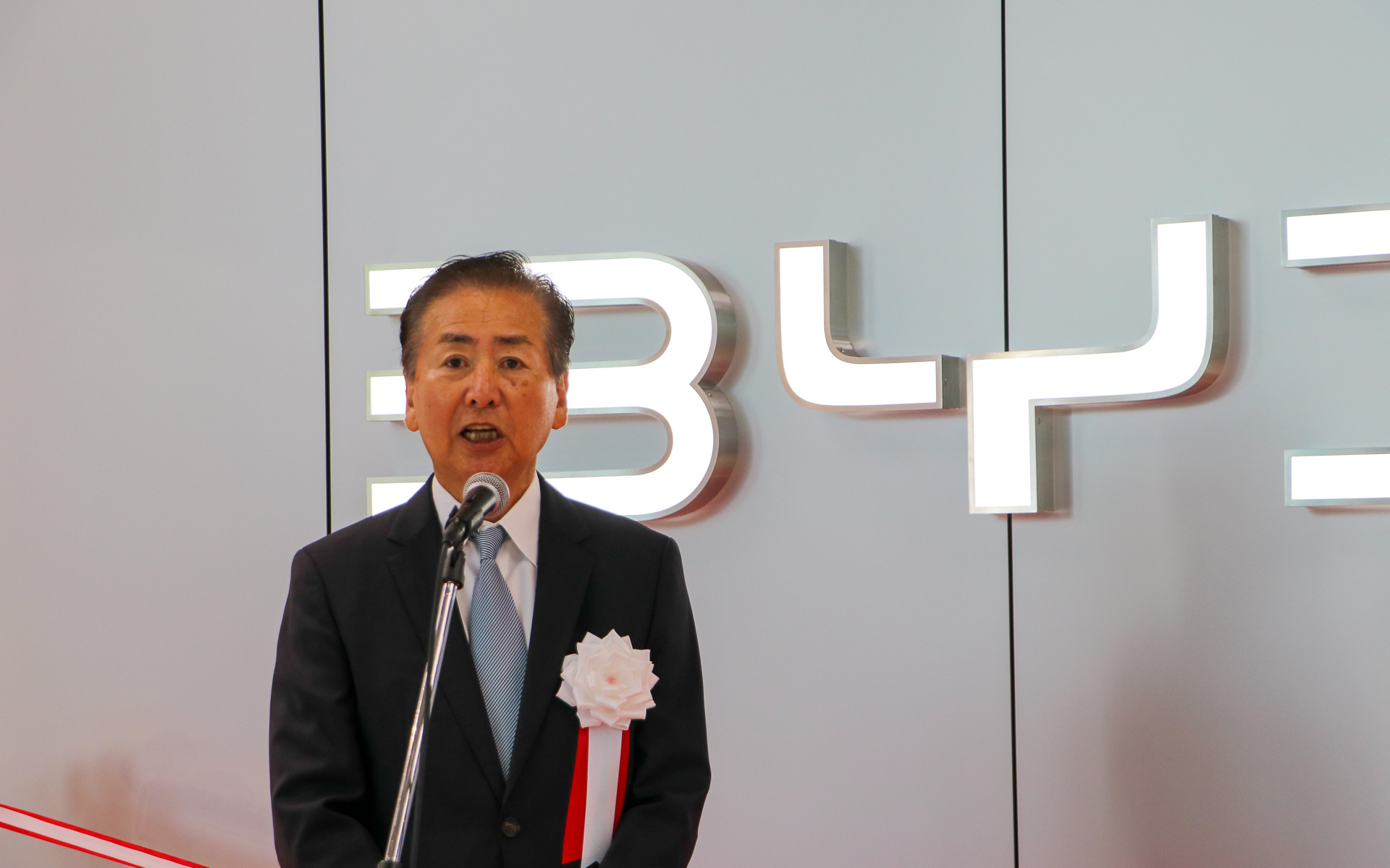 明治産業株式会社 取締役社長である竹内眞哉氏は、セレモニーで明治産業の歴史を紹介しつつ、BYDとの業務提携を経て正規ディーラー開業へとつながった経緯を説明した