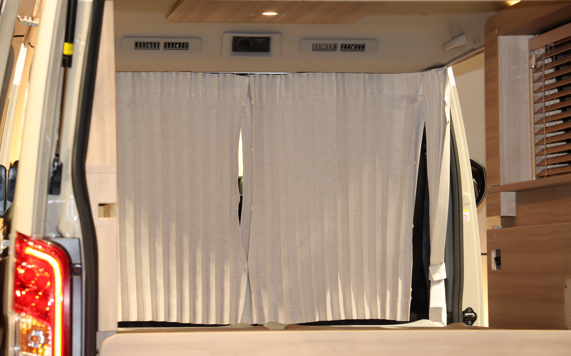 カーテンや木目調の化粧板によってクルマの車内にいることを忘れさせる空間演出