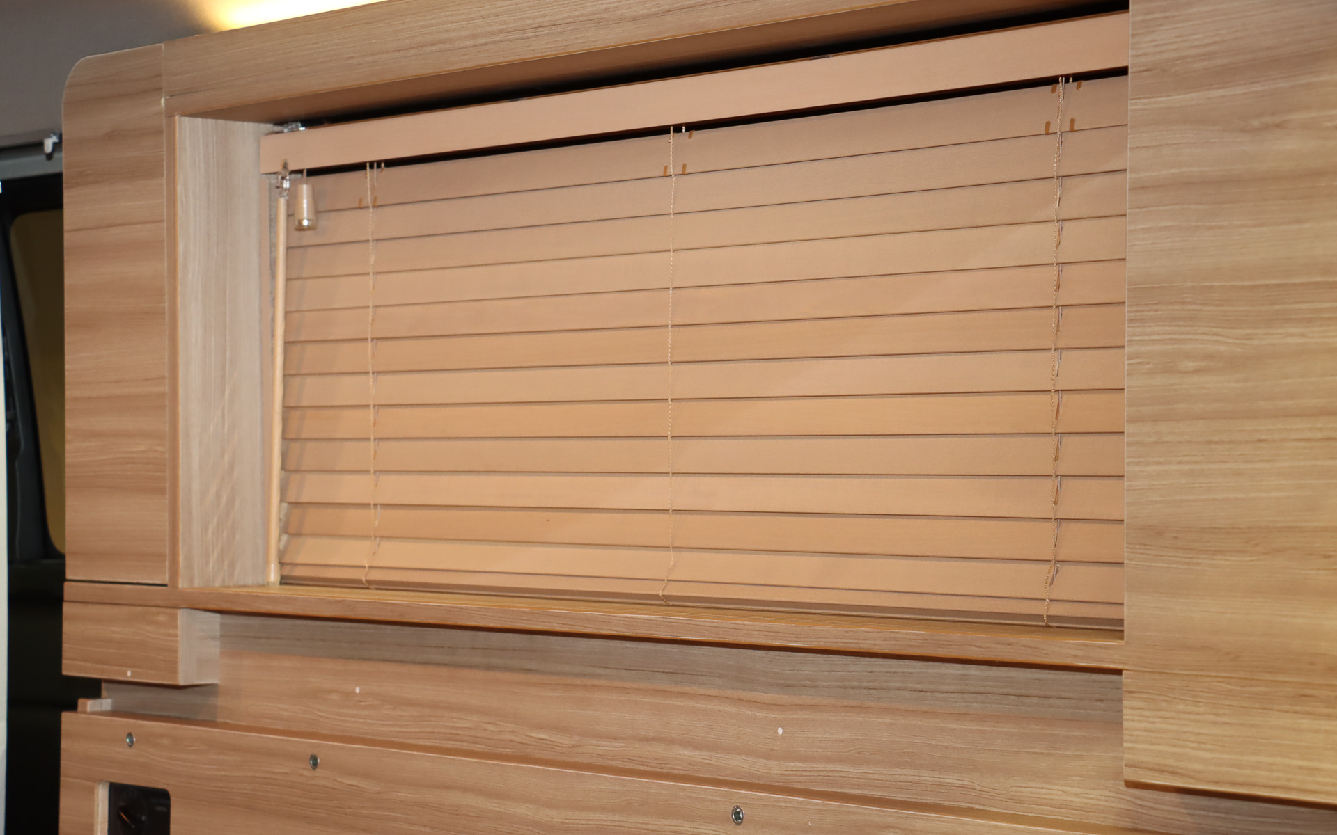 カーテンや木目調の化粧板によってクルマの車内にいることを忘れさせる空間演出