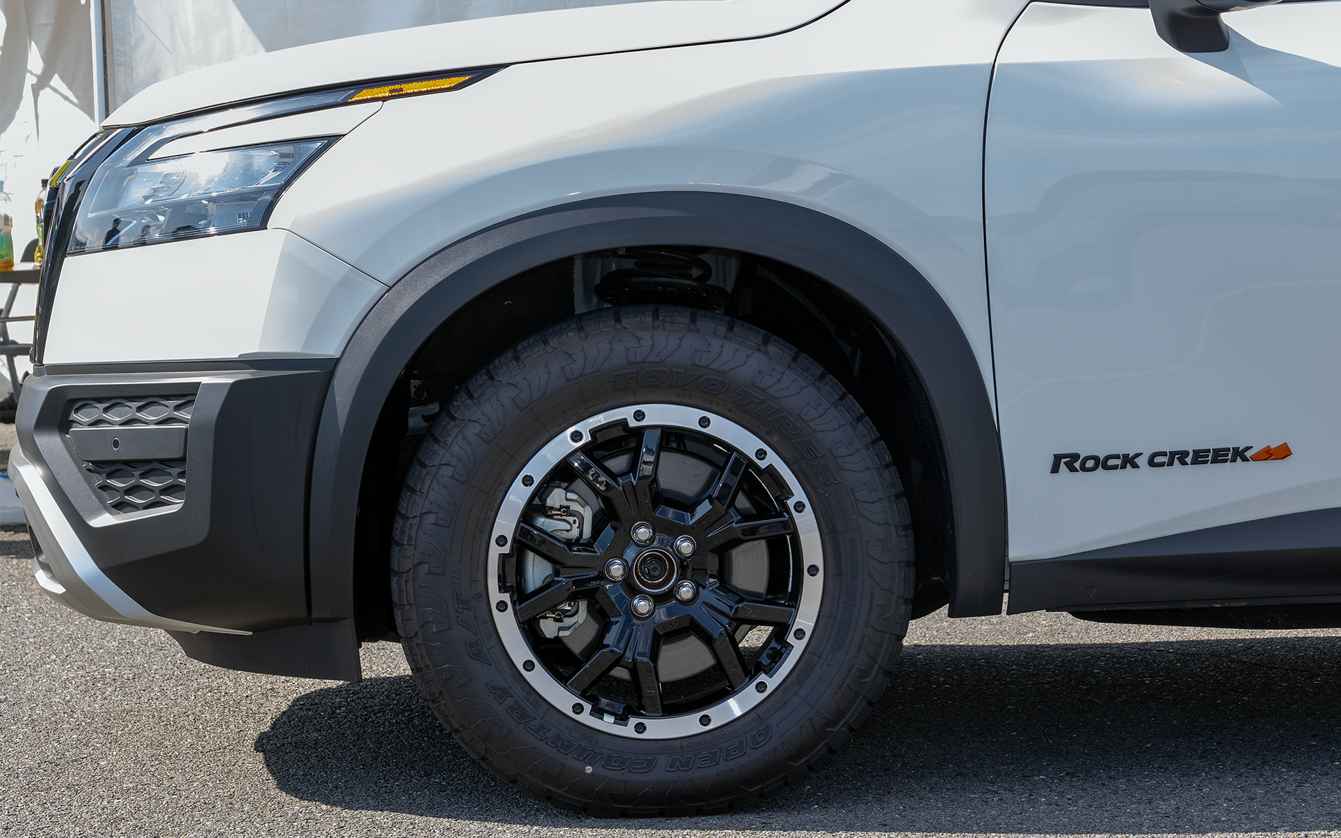 標準車は街中向けのオールシーズンタイヤを履くが、こちらはTOYO TIRESのオープンカントリーATというオフロードも走れるオールテレーンタイヤが標準で装着される．アルミホイールも専用。リフトアップサスペンションも組まれている