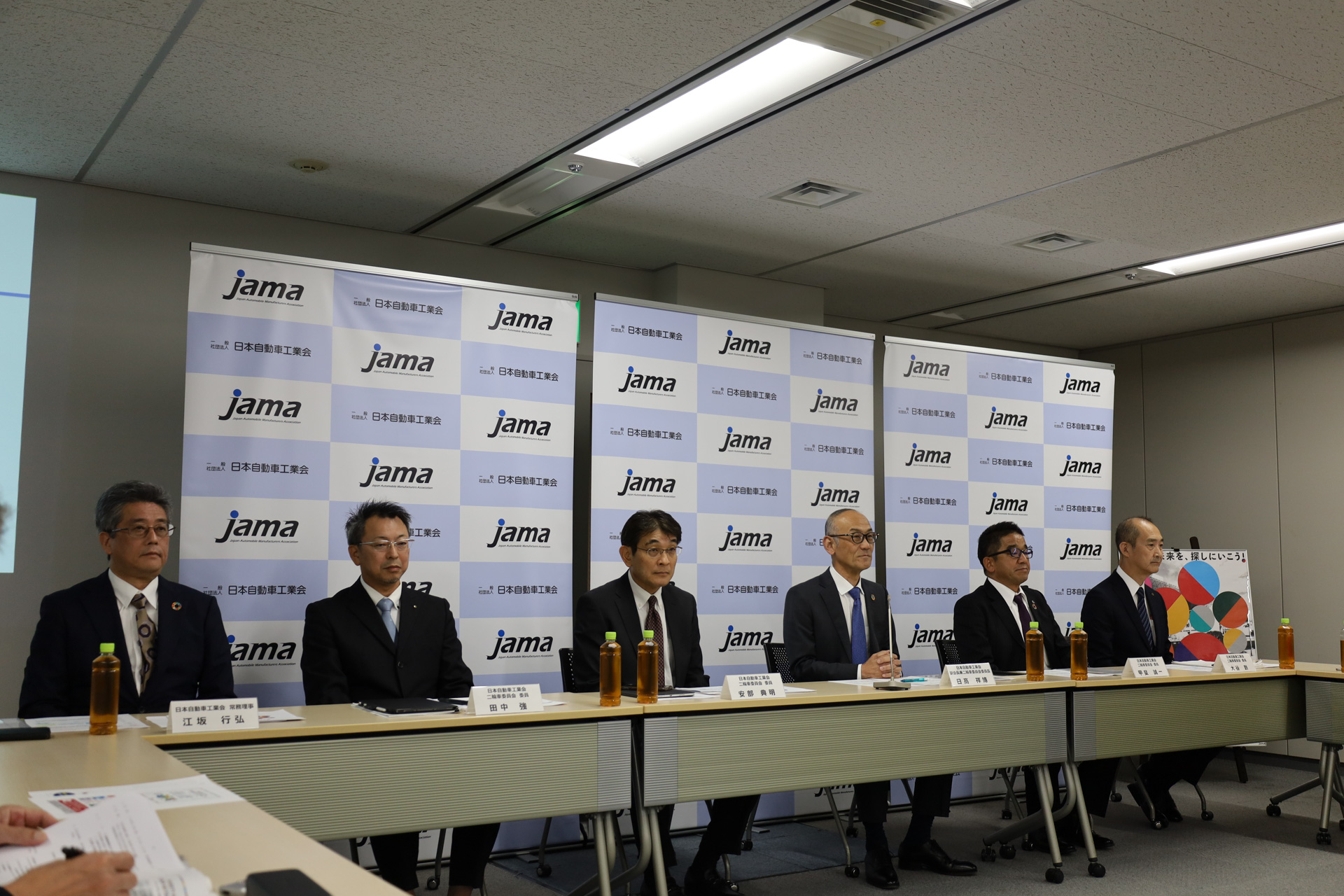 日本自動車工業会 二輪車委員会 委員を務めるカワサキモータースの甲斐誠一氏、スズキの田中強氏、本田技研工業の安部典明氏、ヤマハ発動機の大谷到氏が登壇して、ヤマハ、スズキ、カワサキ、ホンダ、各メーカーの出展概要について紹介した