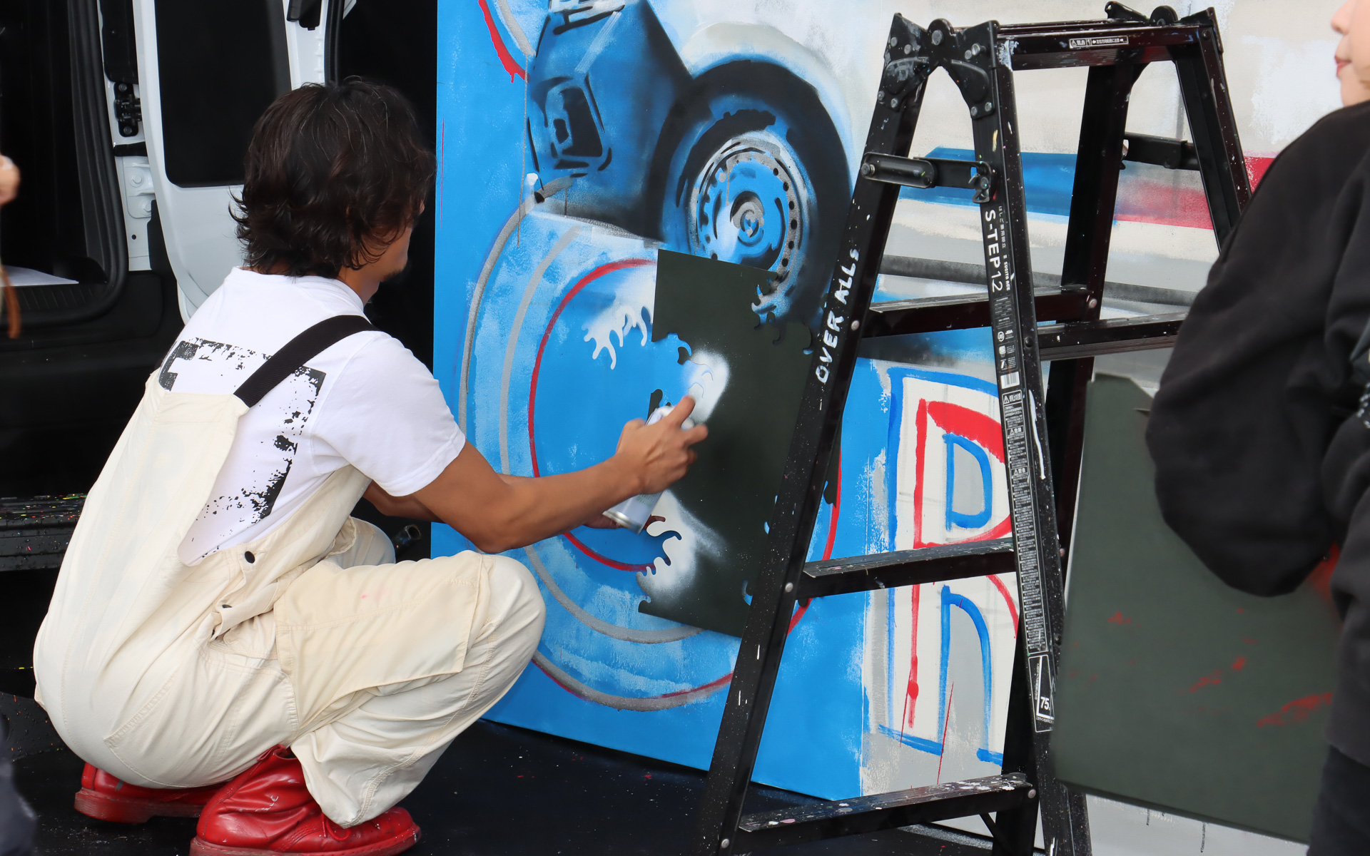 ペイントローラーや缶スプレーなどを遣って壁画製作が進む。細かな模様やラインなどは型紙を使ってペイント