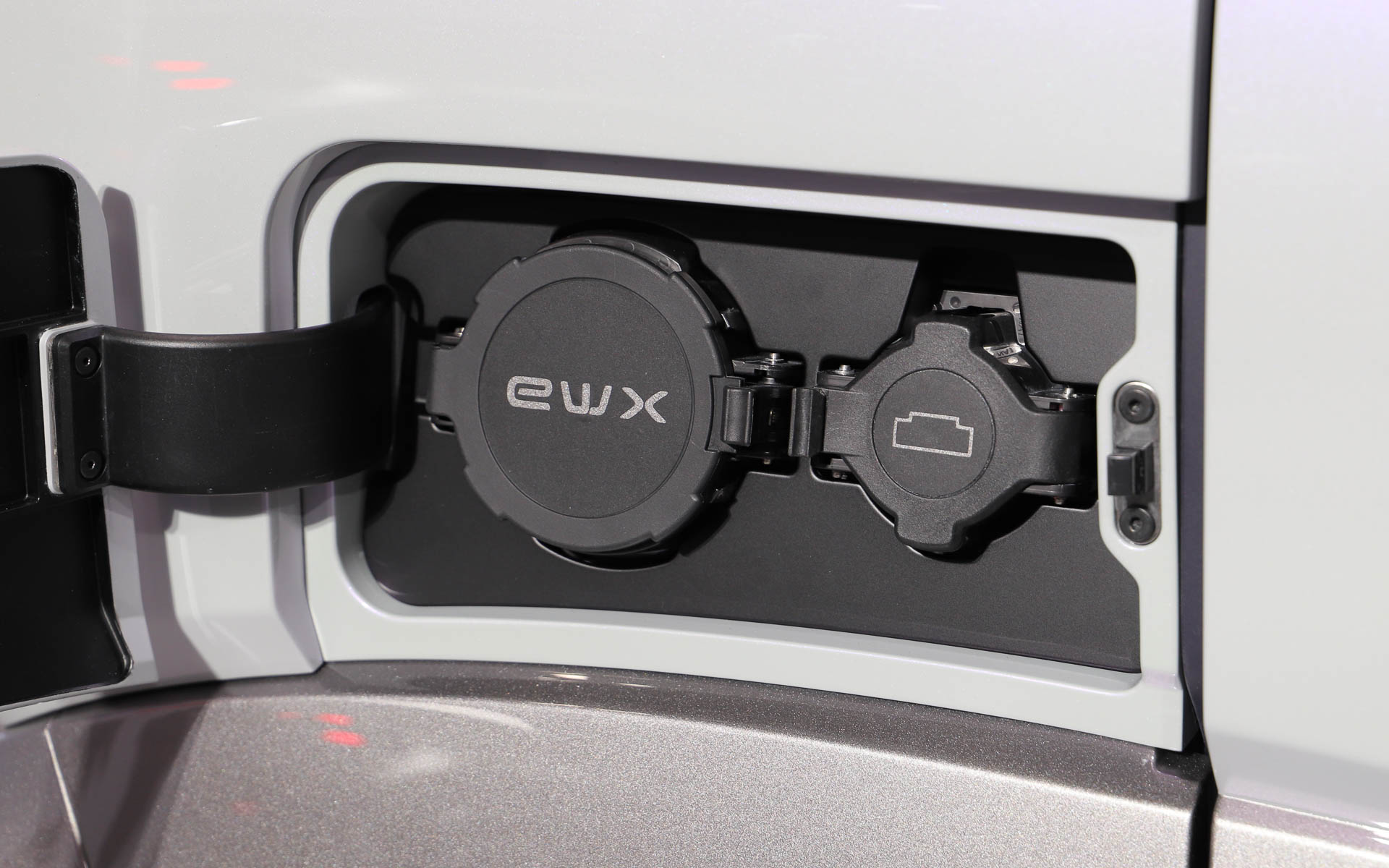 eWX。＋と－の記号をモチーフとして採用し、ホイールデザインからタイヤには連続して＋のデザインが用いられている。充電口には「凸する」デザインとして“凸”をモチーフにしたアイコンを配置。ボディカラーには見る角度によってピンク色が浮かび上がるコダワリ