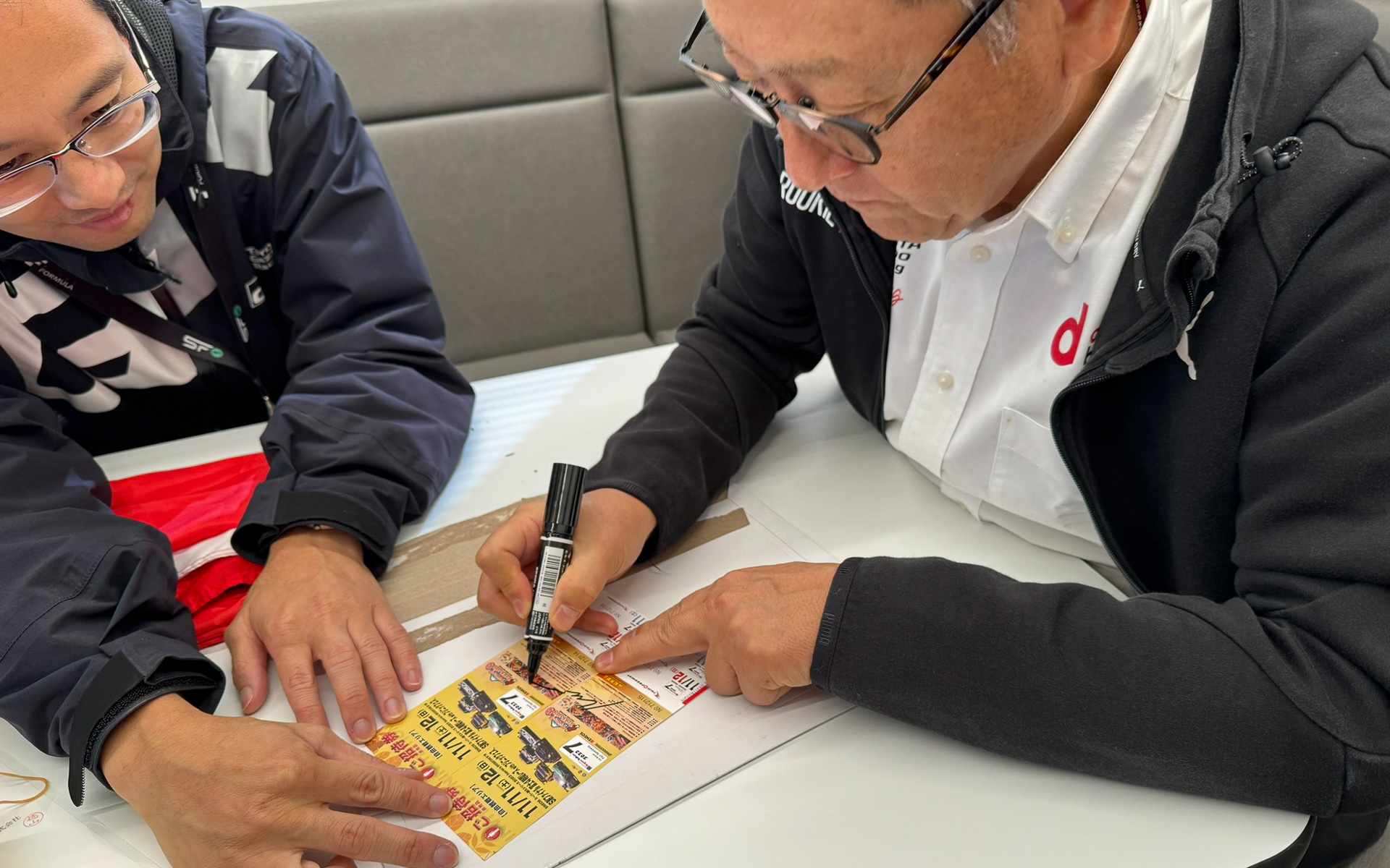 チケットにペアサインをするモリゾウ選手（トヨタ自動車 豊田章男会長）