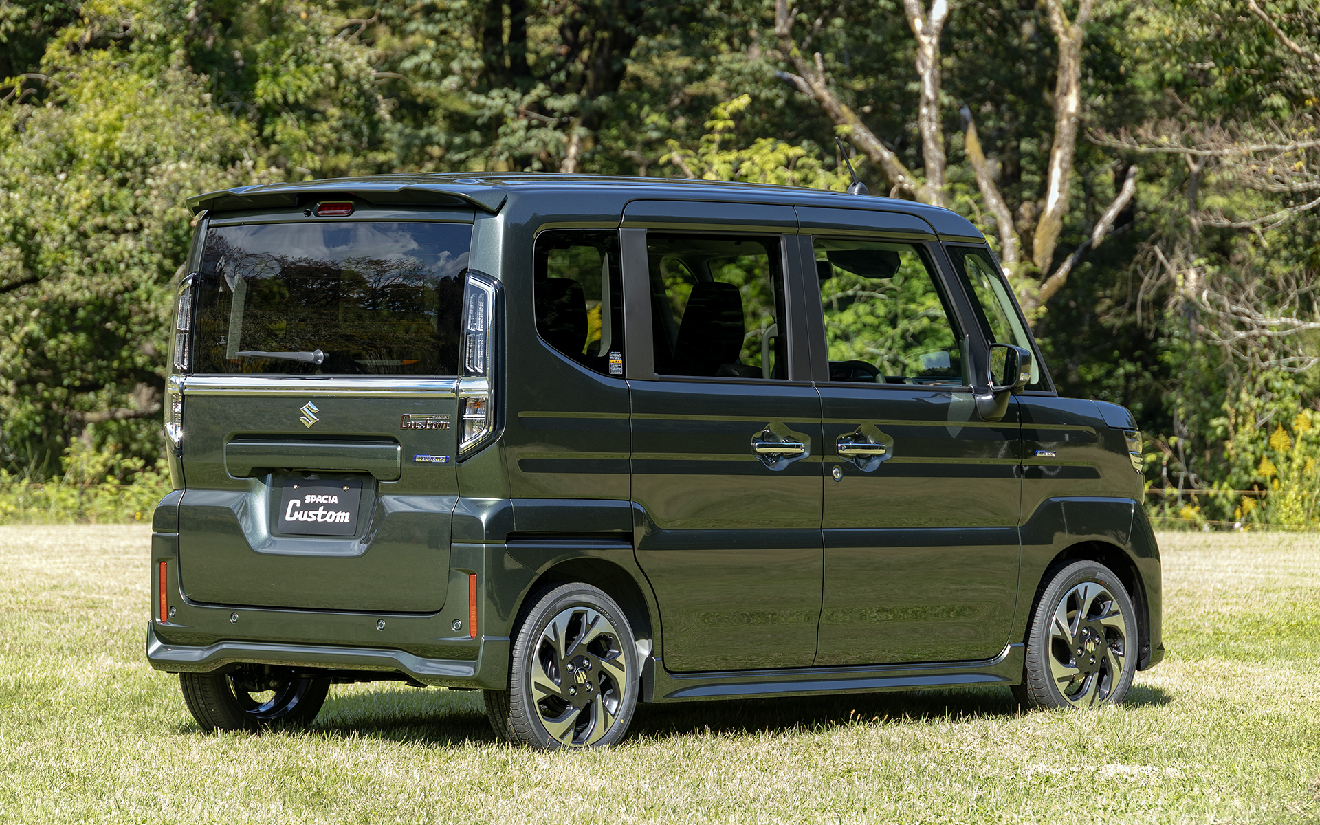 新型スペーシア カスタムのリアビュー。ルーフエンドスポイラーとメッキバックドアガーニッシュが追加される。リアコンビランプはランプ単体でも充実感のあるデザインを目指してデザインされ、LEDテールストップランプにはきらびやかな光り方をするインナーレンズを採用して標準車と差別化される