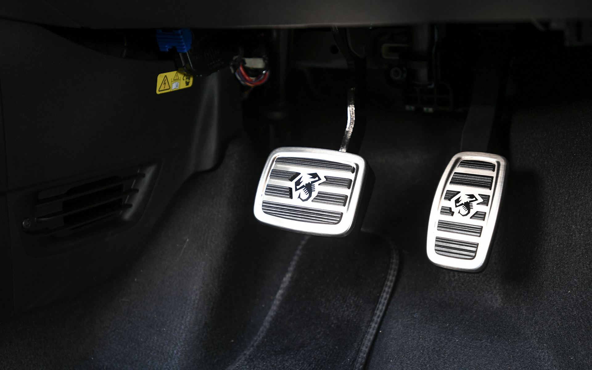 黒を基調としたシックでスポーティなインテリア。インストルメントパネル、ステアリング、ヘッドレスト一体型スポーツシートなどにアルカンターラ素材を採用し、高級感を演出。ヘッドレストには「Abarth 500e」専用のロゴをあしらい、ブルーとイエローのステッチを施した一体型のスポーツシート、ステアリングホイールにあしらったブルーのトップマークとともにスポーティさを高めている