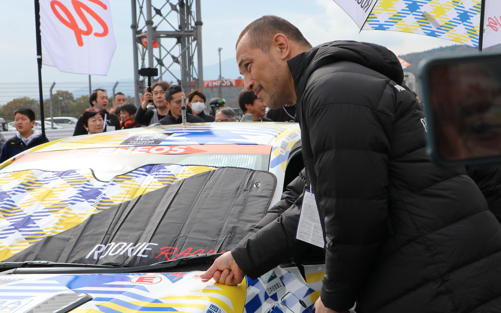 32号車 ORC ROOKIE GR Corolla H2 conceptのボンネットにステッカーを貼る室伏広治スポーツ庁長官