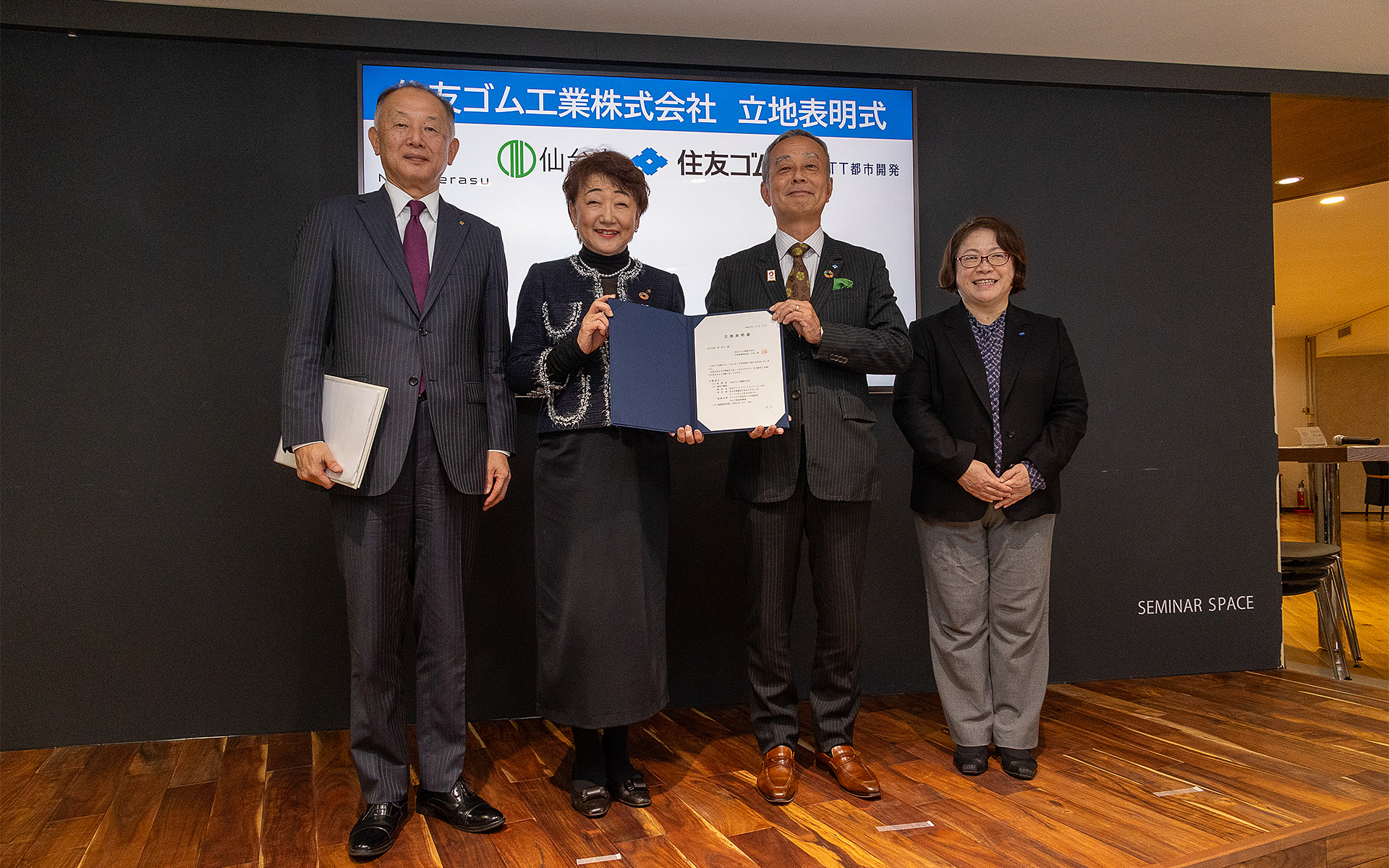 立地表明式の出席者。左から、一般財団法人光科学イノベーションセンター 副理事 小林正明氏、仙台市長の郡 和子氏、住友ゴム工業株式会社 取締役常務執行委員 村岡清繁氏、NTT都市開発株式会社 東北支店長の大久保洋子氏。住友ゴムの村岡氏から郡市長に立地表明書が手渡された