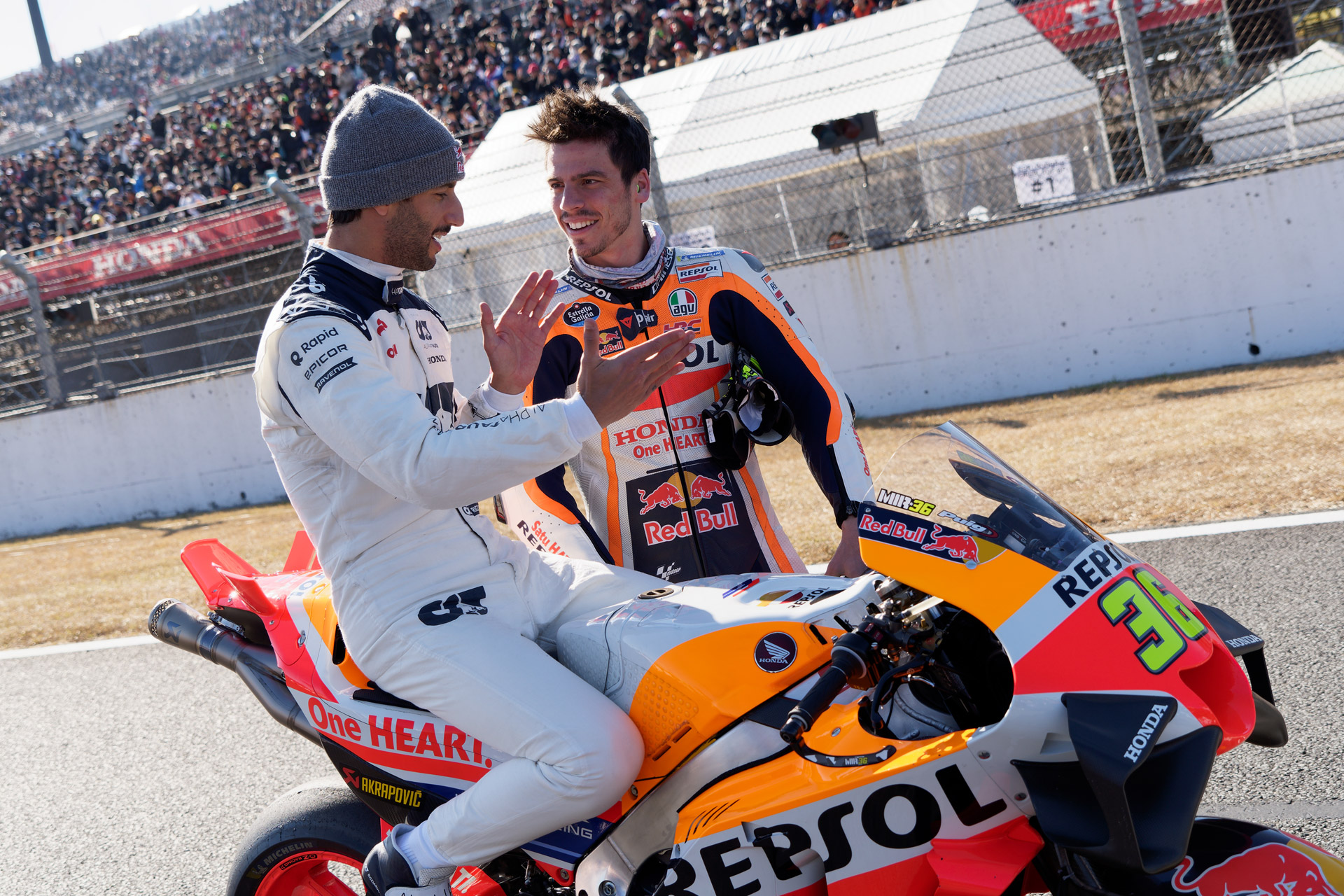 F1のダニエル・リカルド選手がMotoGPマシンにまたがってミル選手と情報交換する風景も