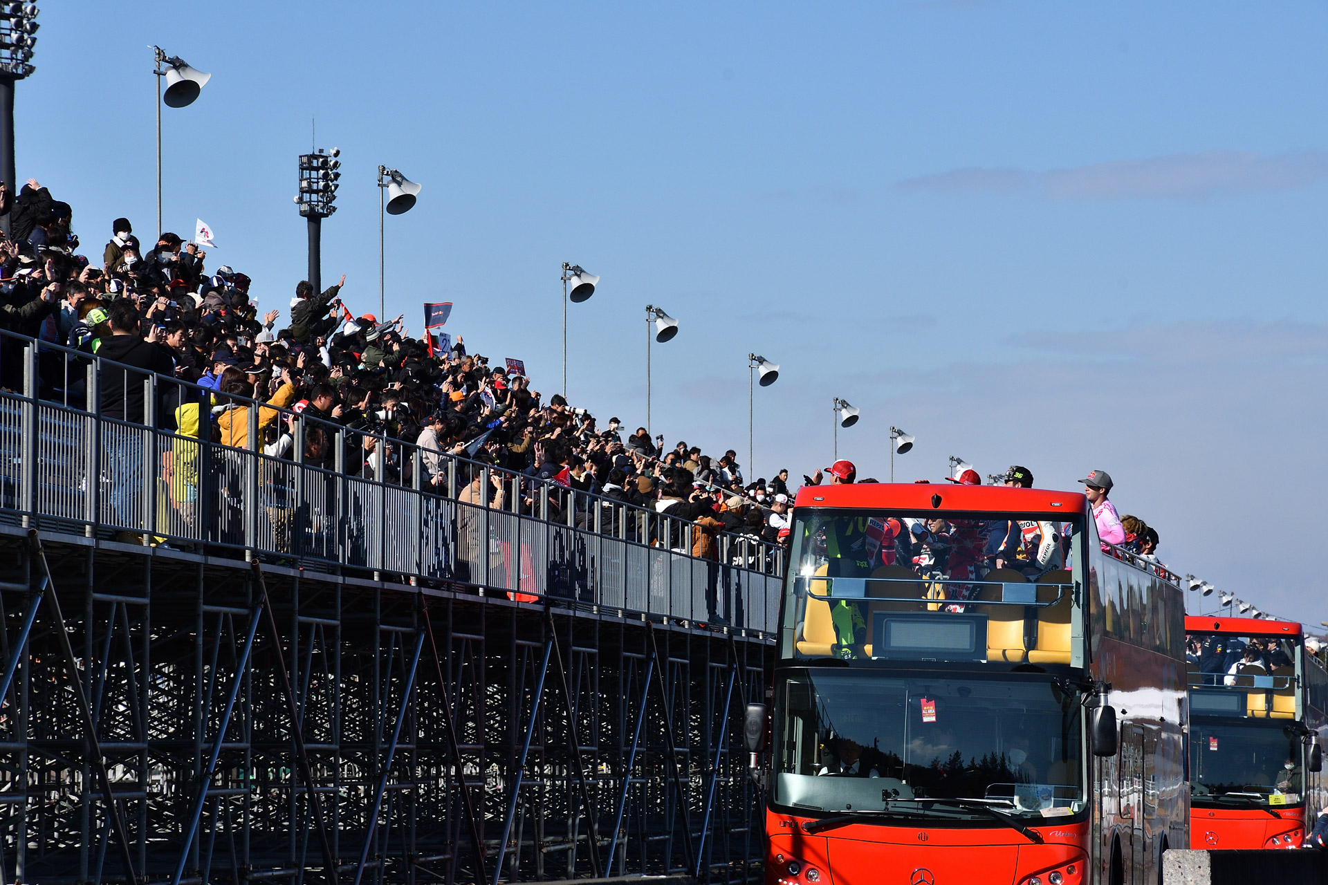 バスに乗った選手が観客の間近を通過してファンサービス