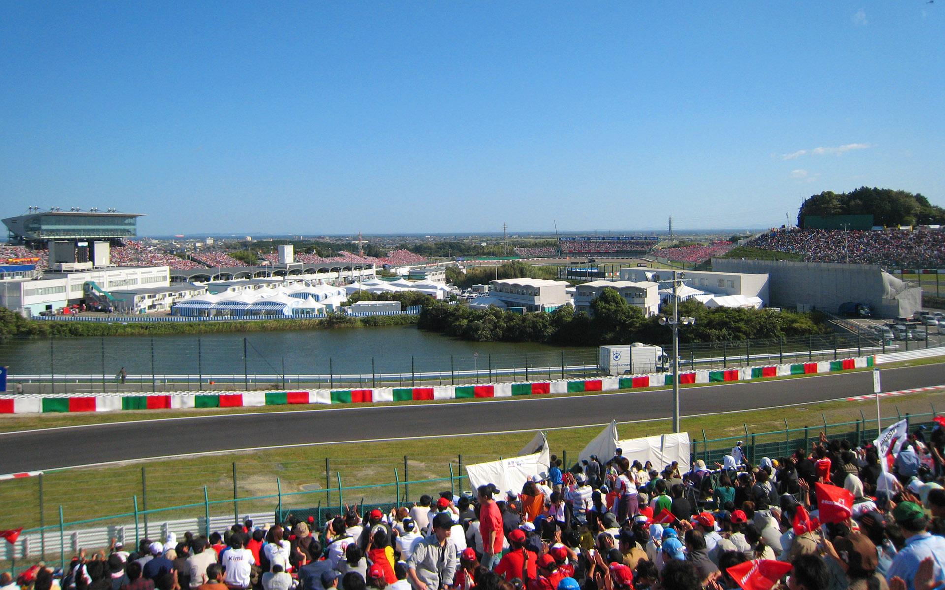 2006年の東コース。現在のE席付近から撮影。逆バンクからダンロップは自由席。ストレートエンドは仮設スタンドが並んでいる。拡大した写真は<a href="https://dc.watch.impress.co.jp/cda/parts/image_for_link/69349-4852-8-2.html" class="n" target="_blank">こちら</a>にも