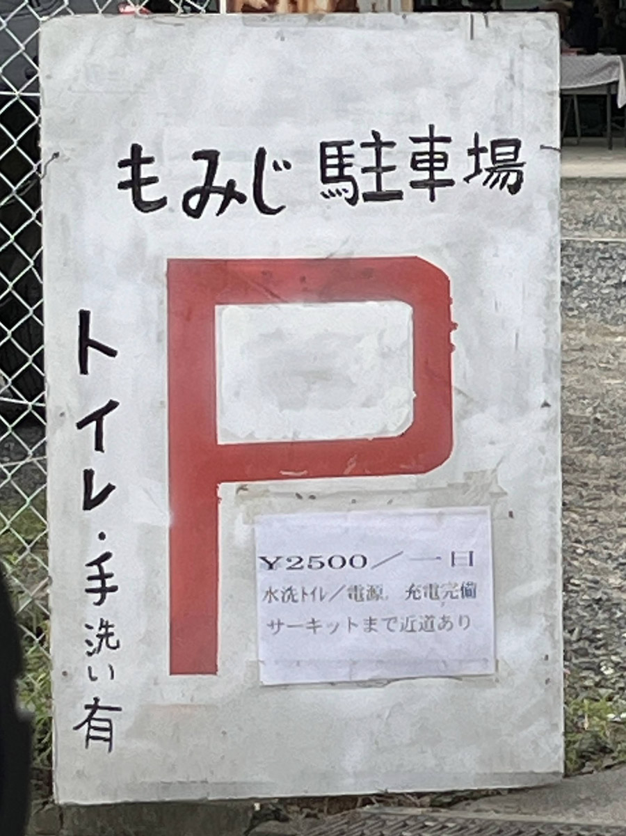 L：2500円。道沿いの駐車場。道伯1丁目の交差点経由でサーキット前交差点まで1.8km。サーキット駐車場を抜ける近道は推定1.4km