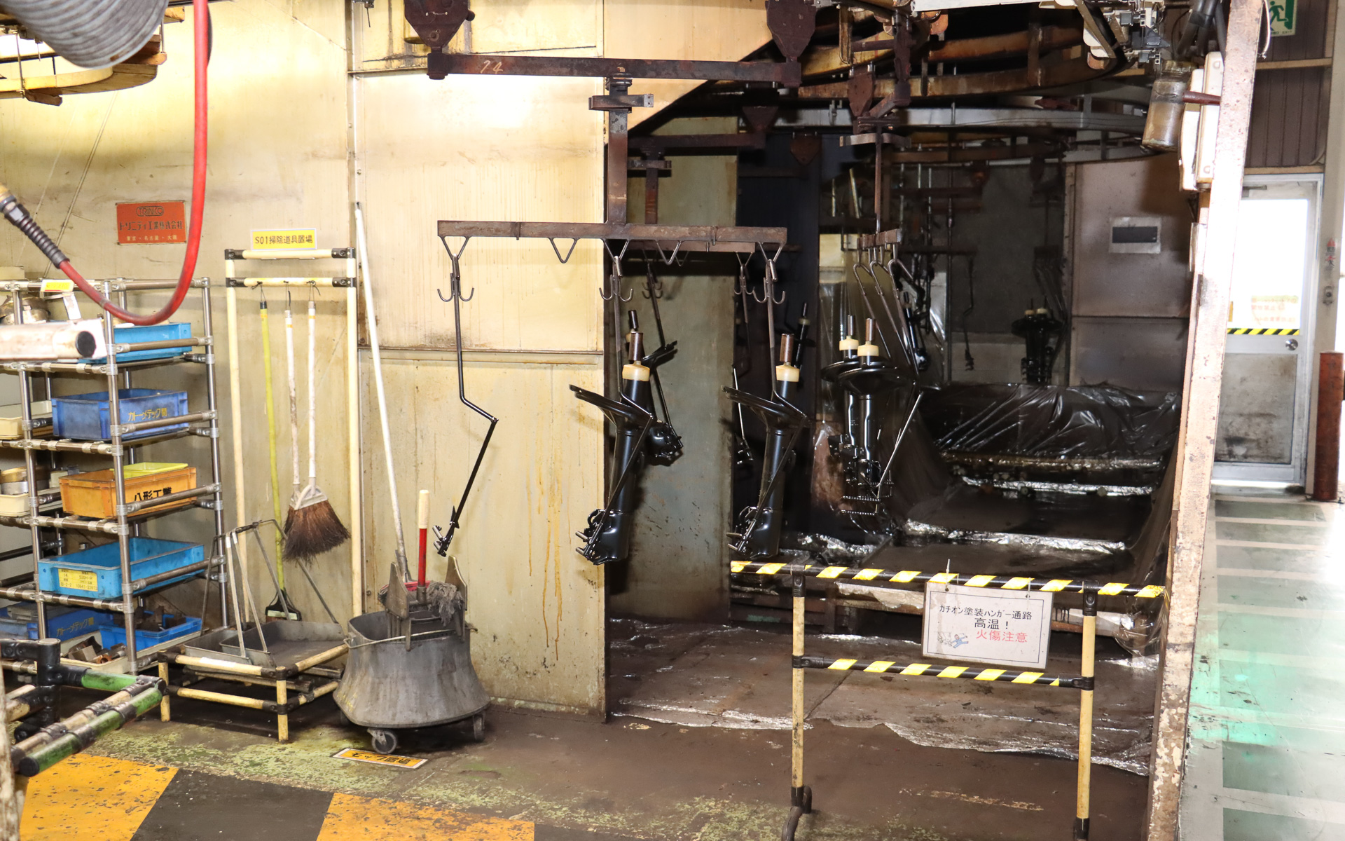 足場が組まれた2階部分でカチオン電着塗装を実施。製品はハンガーに吊るされたまま、乾燥と冷却を行ないながら次の工程に運ばれていく