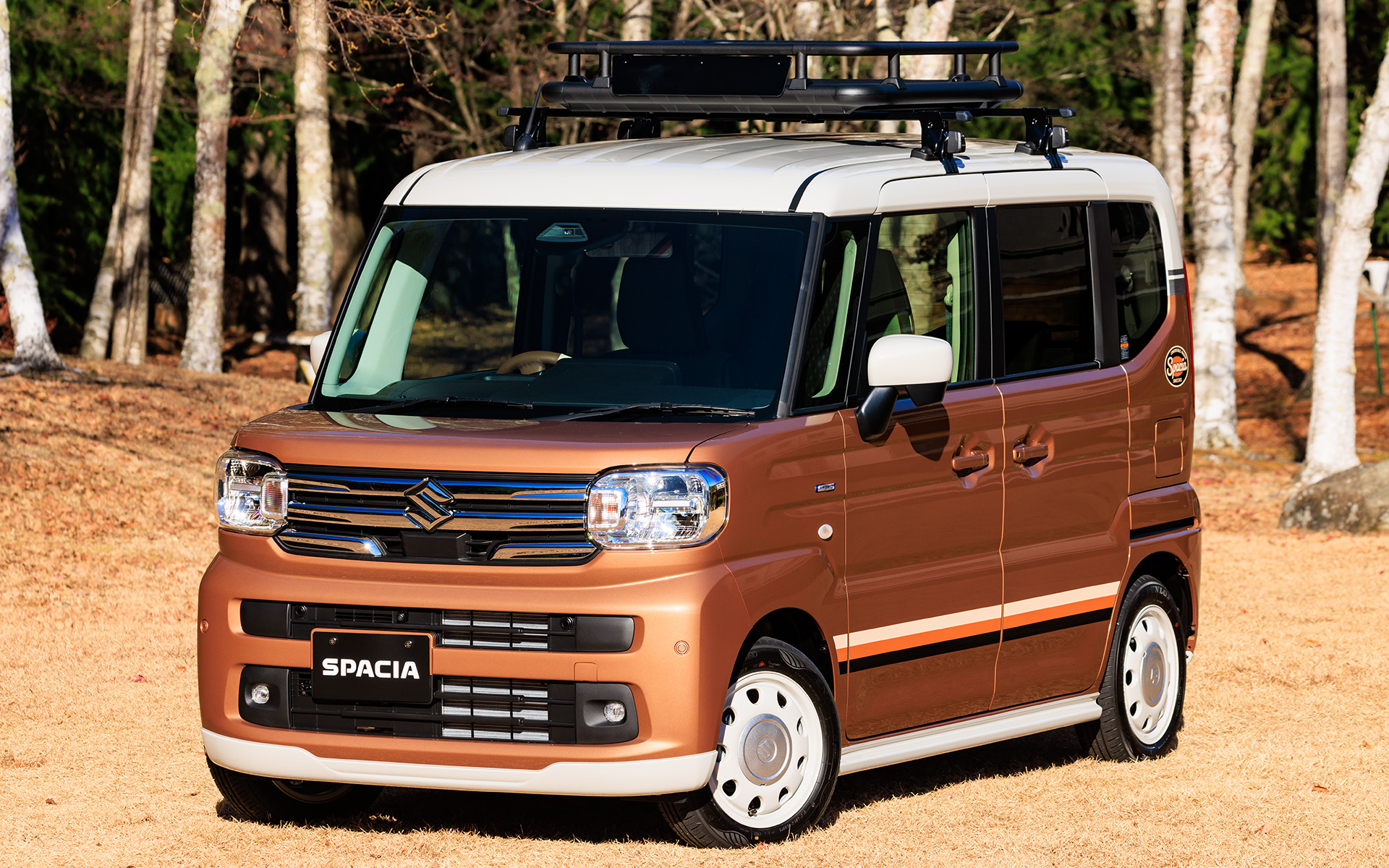 スペーシア用品装着車。フロントグリル（クロームメッキ）や、ソフトベージュのフロントアンダーガーニッシュ、サイドアンダーガーニッシュ、リアアンダーガーニッシュ、ビンテージストライプのサイドデカール、バックドアデカール、14インチアルミホイール（ソフトベージュ）×アルミホイールハーフキャップ（シルバー）などを装着