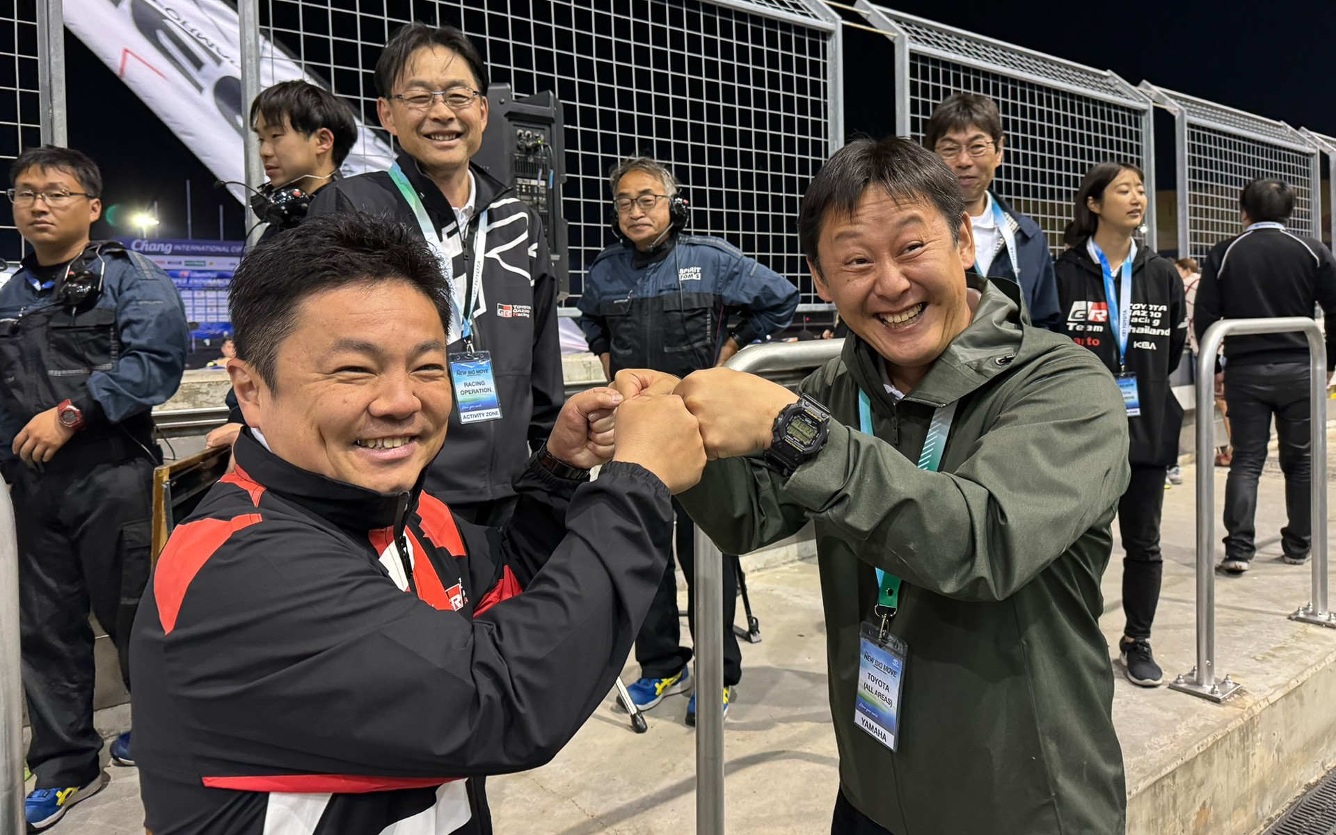 10時間耐久レース直後、新型プリウスの完走をよろこぶ開発者 大矢賢樹氏（右）。TOYOTA GAZOO Racing Company プレジデント 高橋智也氏（左）とグータッチ。後方ではGAZOO Racing Company GRプロジェクト推進部 GRZ チーフエンジニア 末沢泰謙氏も祝福