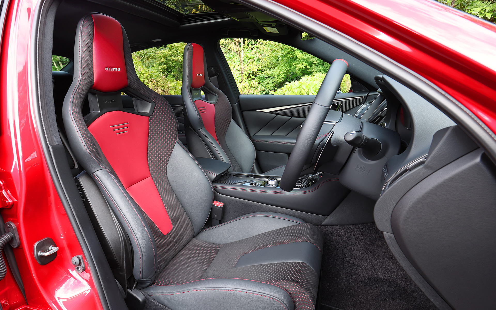 インテリアではスカイライン 400Rの質感をそのままに全体を黒基調で統一。コクピットまわりにはレッドセンターマーク付きのNISMO専用本革巻ステアリング、280km/hスケールのスピードメーター、NISMOロゴを配したレッドリングタコメーターを採用。さらにNISMO専用チューニングのレカロ製スポーツシートをオプション設定しており、こちらはスエード調表皮の貼り分け位置にこだわり、急旋回時でもシート中心部に体圧が残る高いホールド性を実現