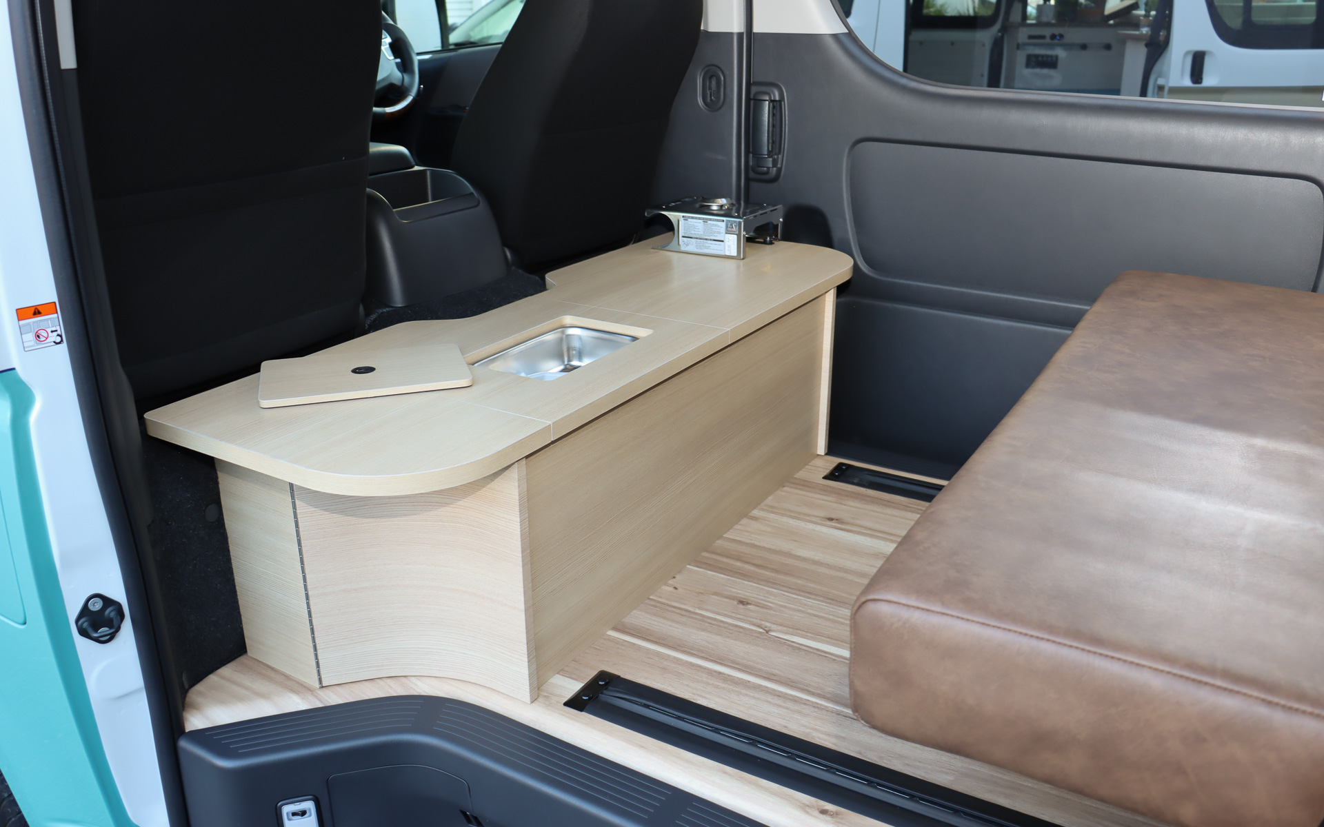 フロントシート後方に「簡易キッチン」を装備。シンク、着脱式コンロ、収納スペースを備え、テーブルとしても利用可能