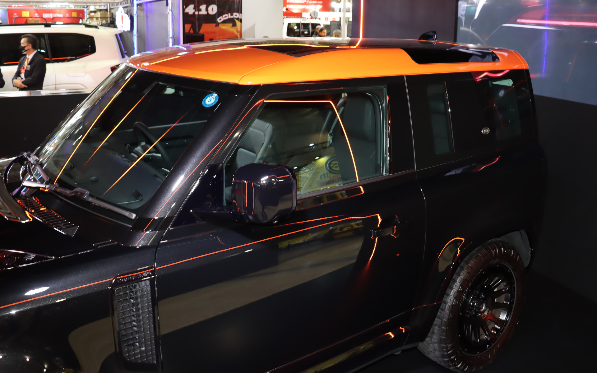 フロントグリルやルーフにG'ZOXブランドのイメージカラーであるオレンジの加飾を設定。また、オレンジの光がブースの天井部分を斜めに走り、リアルガラスコート class Mが施工されたボディ表面を美しく彩っていた