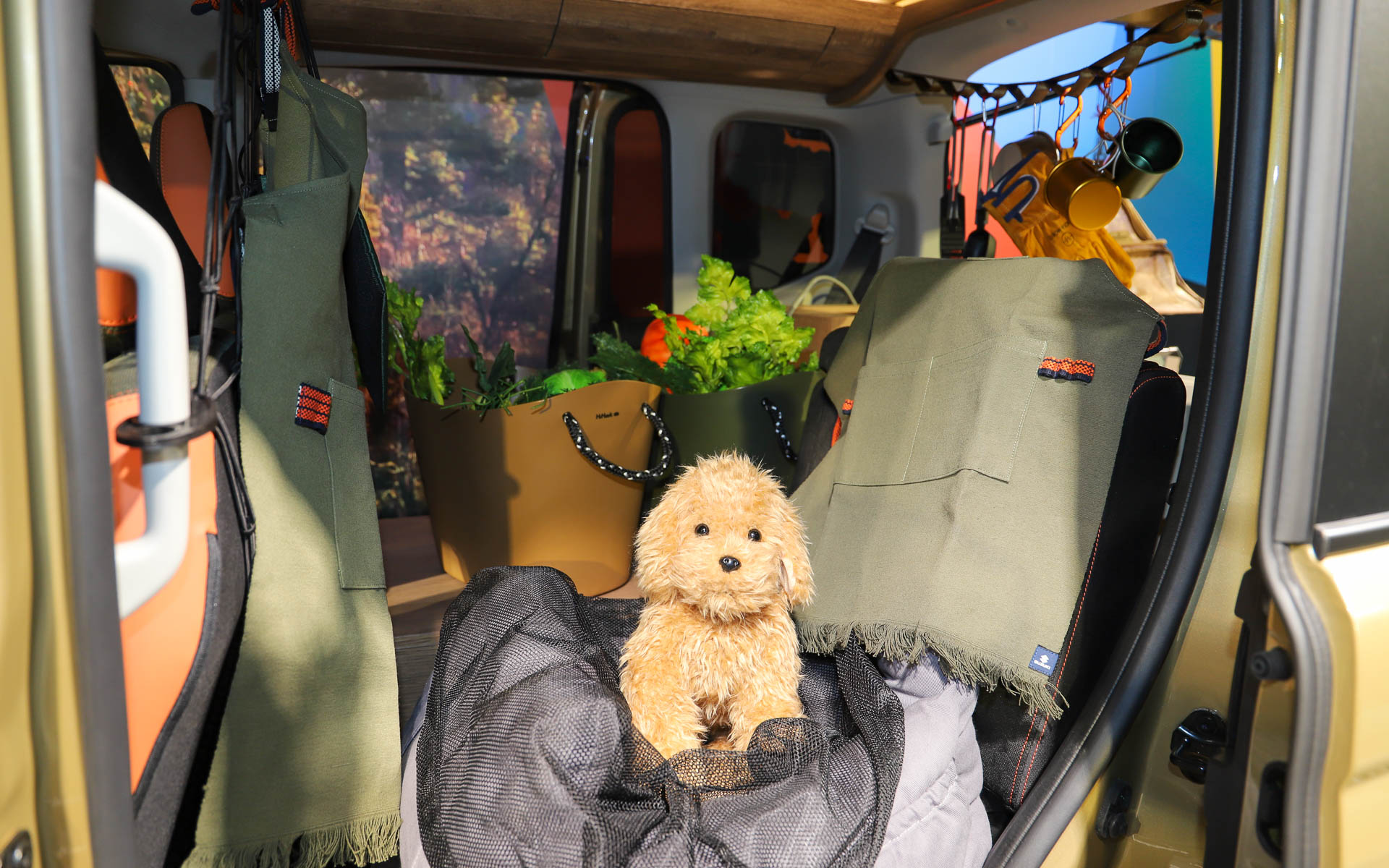 犬と一緒に写っているカーキ色にオレンジのアクセントが入ったエプロンや、ロゴ入りの小物類は今後販売されるかもしれないアイテム