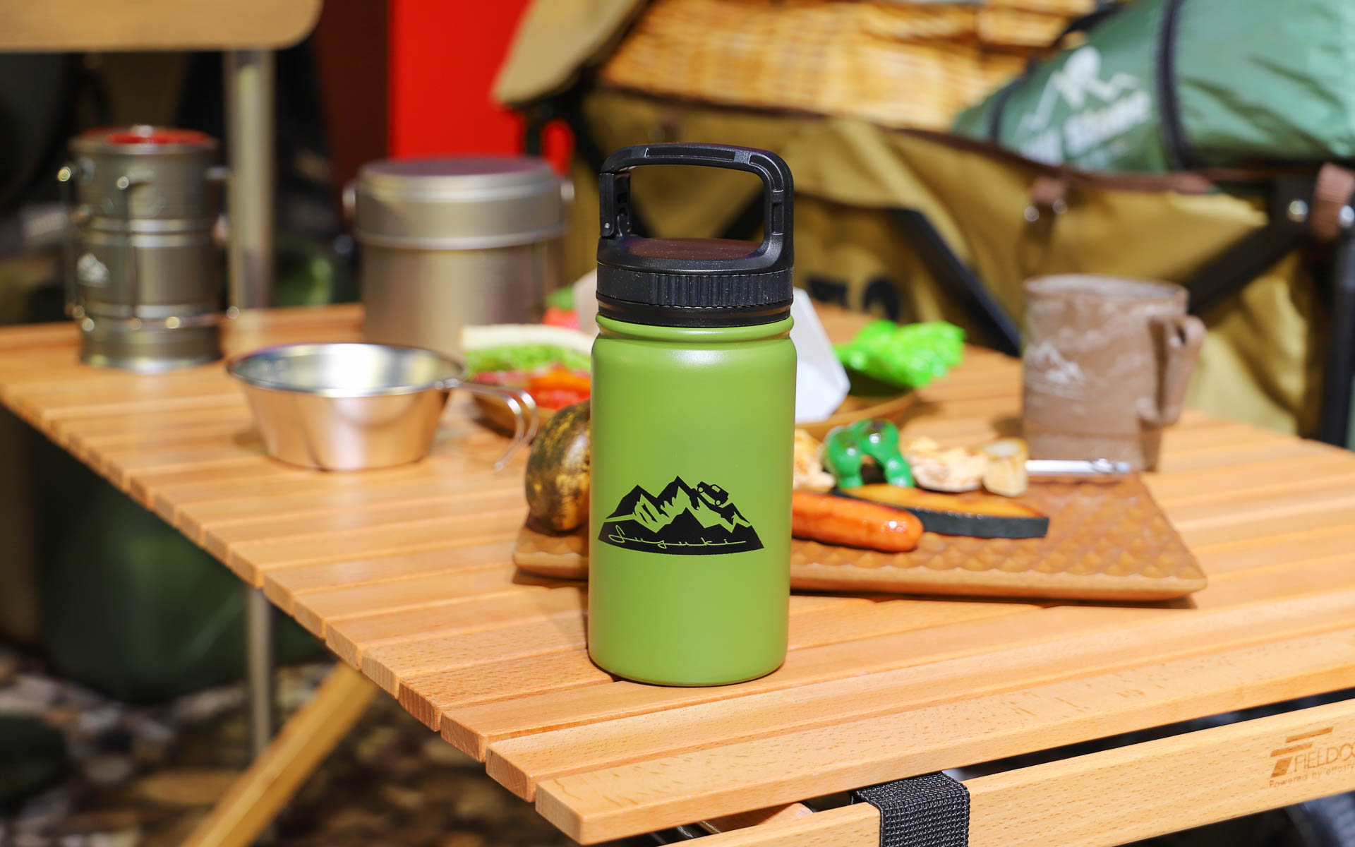 犬と一緒に写っているカーキ色にオレンジのアクセントが入ったエプロンや、ロゴ入りの小物類は今後販売されるかもしれないアイテム