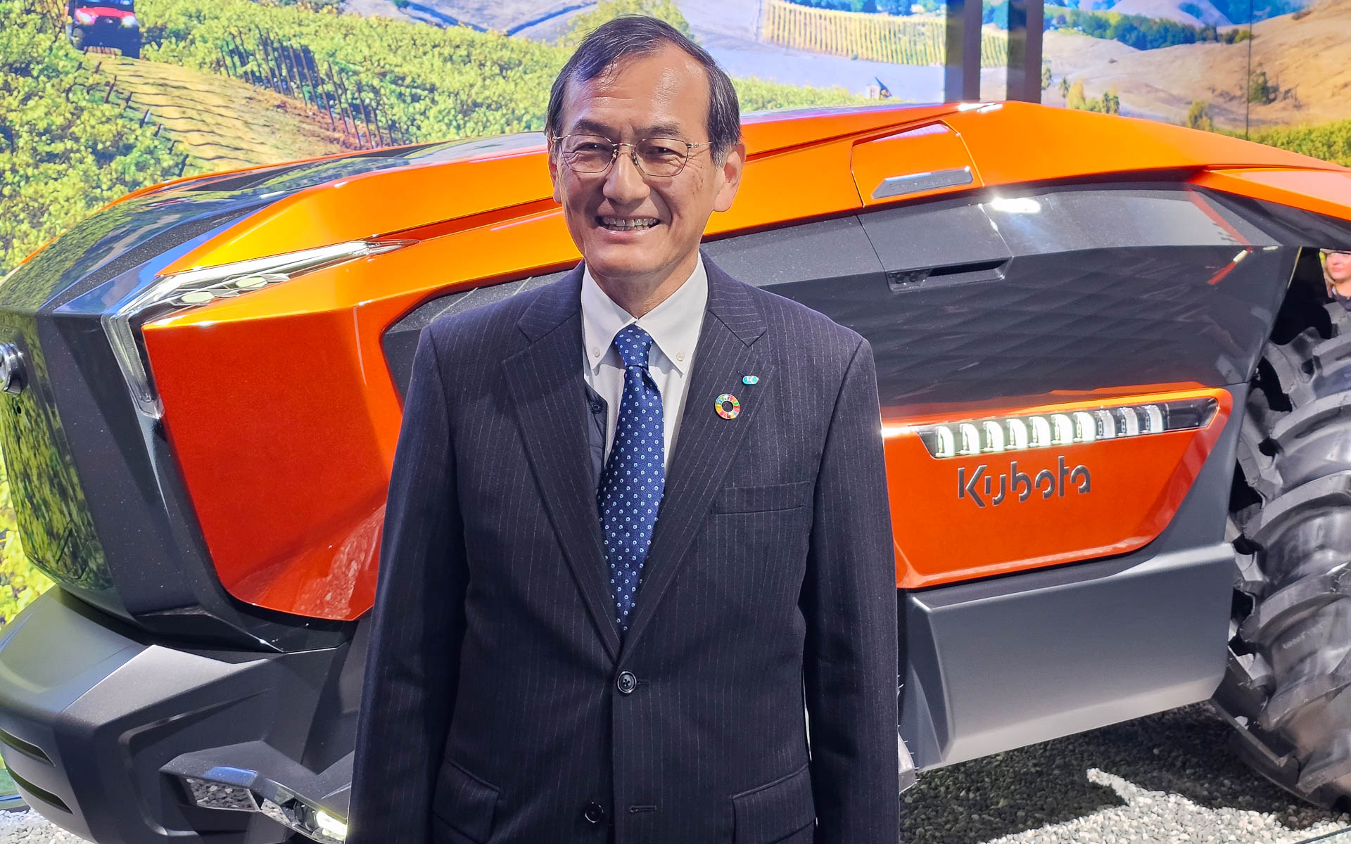 AI電動トラクター・プロトタイプ「NEW AGRI CONCEPT」の前で記念撮影に応じる株式会社クボタ 代表取締役社長 北尾裕一氏