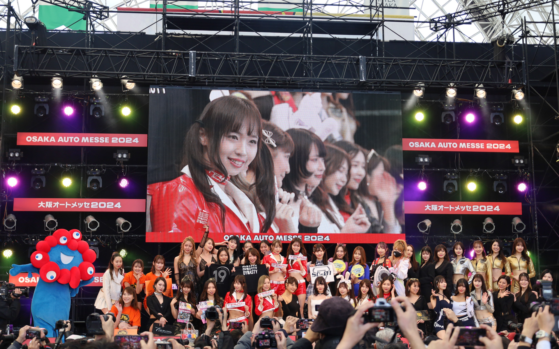 出展ブースのコンパニオンによるステージイベントにミャクミャクも登場