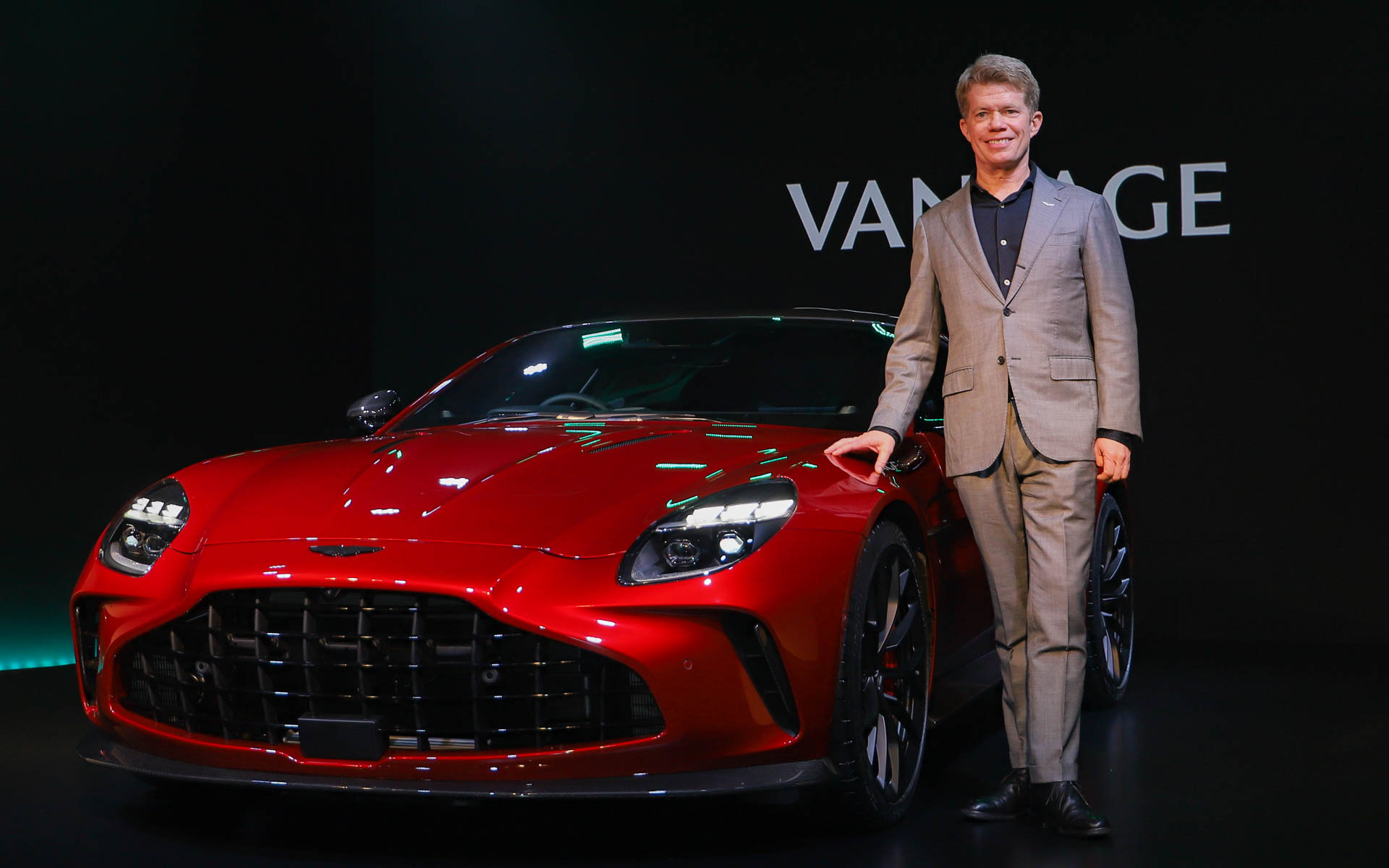 新型ヴァンテージと、発表会であいさつを行なったアストンマーティン APAC リージョナルプレジデント グレゴリー・アダムス氏