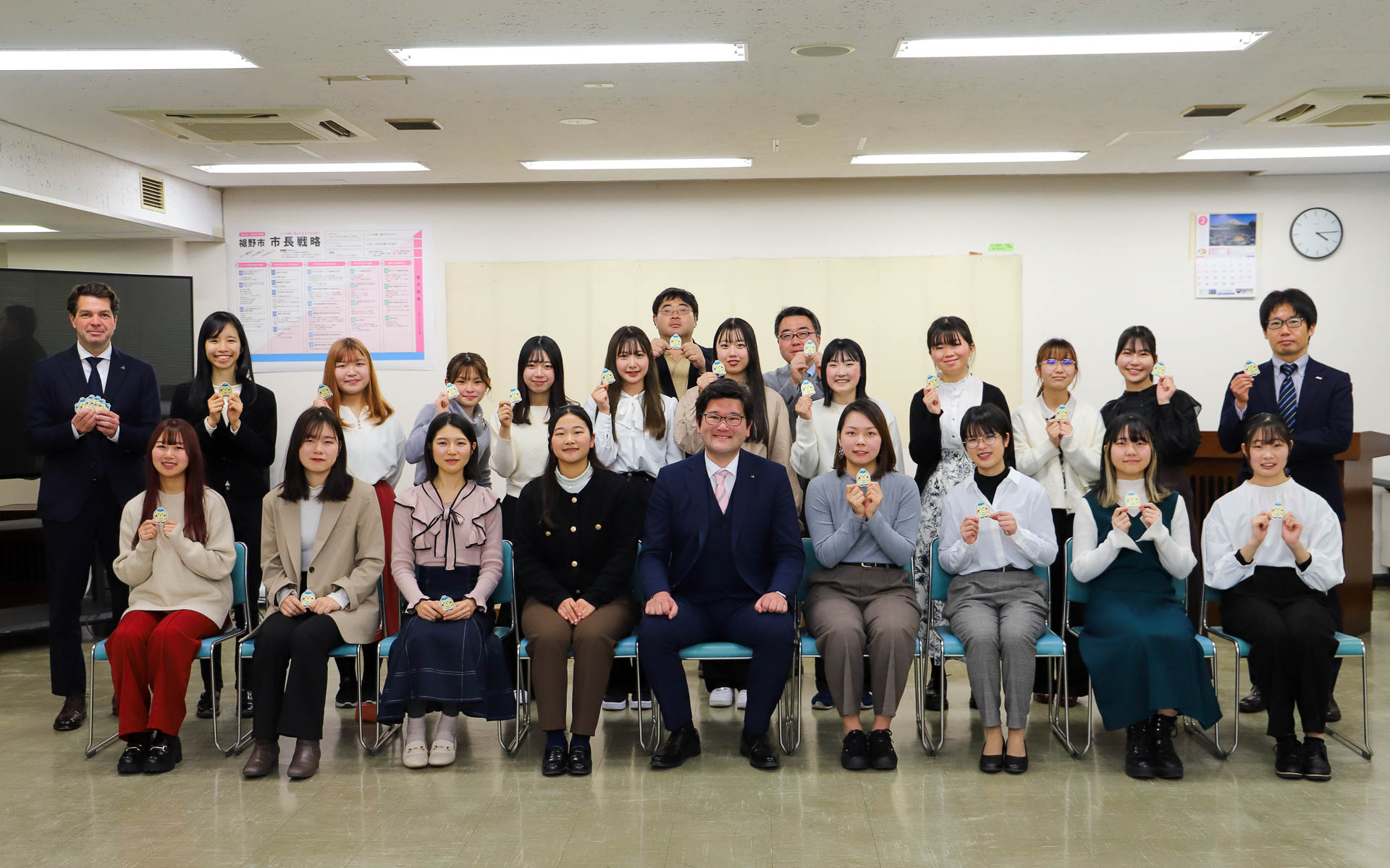 裾野市役所でLED照明を活用したスマート道路灯の新たな活用法について京都女子大学の学生が発表。裾野市長やダッソー・システムズ社長、NTTコミュニケーションズ担当者らが出席して発表に耳を傾けた