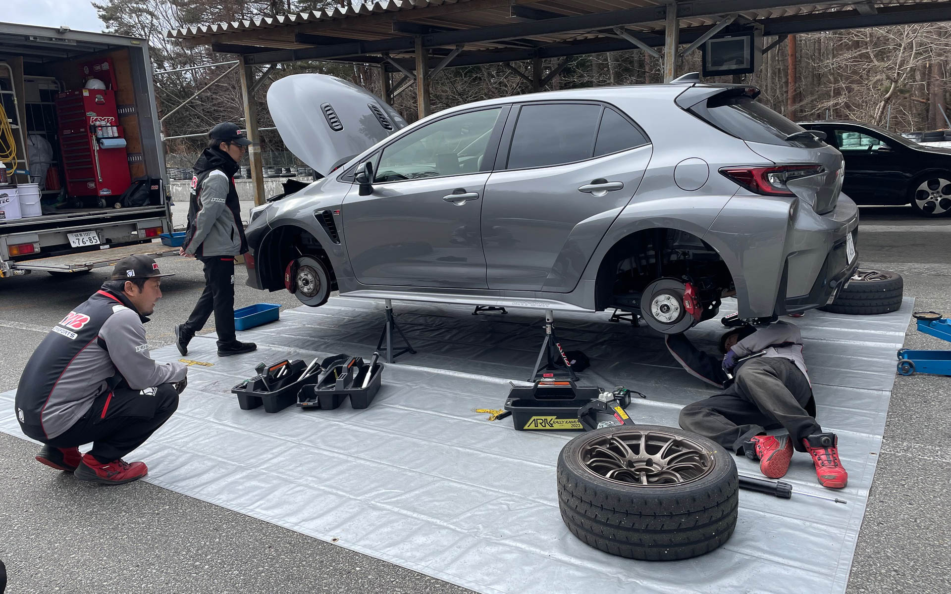 カヤバラリーチームの作業。運転訓練の合間に時間を決めて前後のショックアブソーバーを交換した。プロではないものの早い作業で、ほぼ時間内に終了